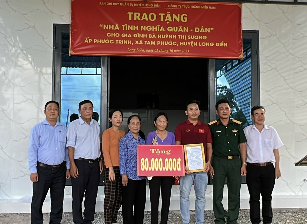 Đại diện Ban CHQS huyện Long Điền và chính quyền địa phương trao biểu trưng tài trợ “Nhà tình nghĩa quân – dân” cho gia đình bà Trần Thị Sương.