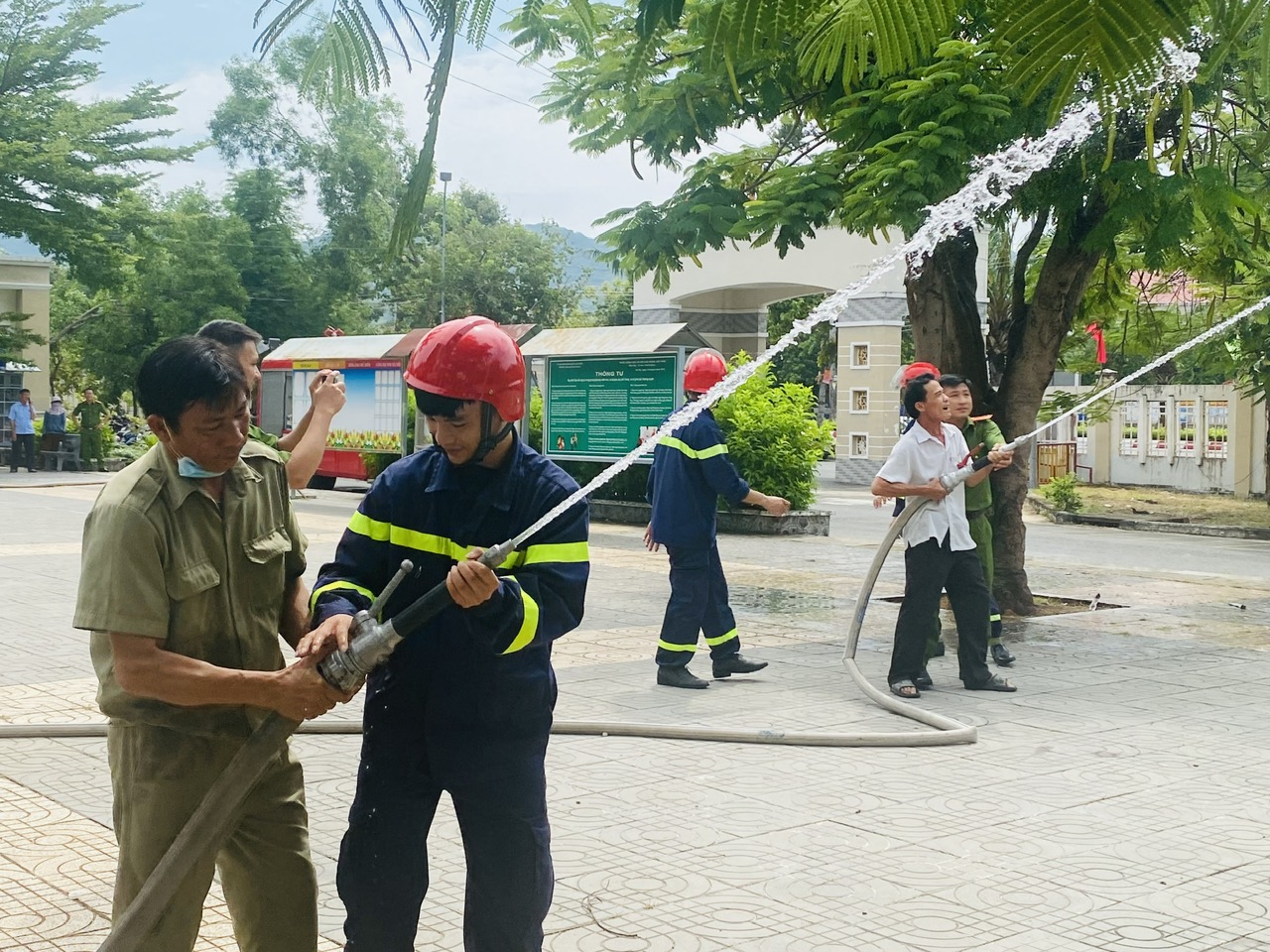 Cán bộ, chiến sỹ Đội Cảnh sát PCCC và CNCH, Công an huyện Long Điền hướng dẫn người dân thực hành phun nước vào đám cháy. 