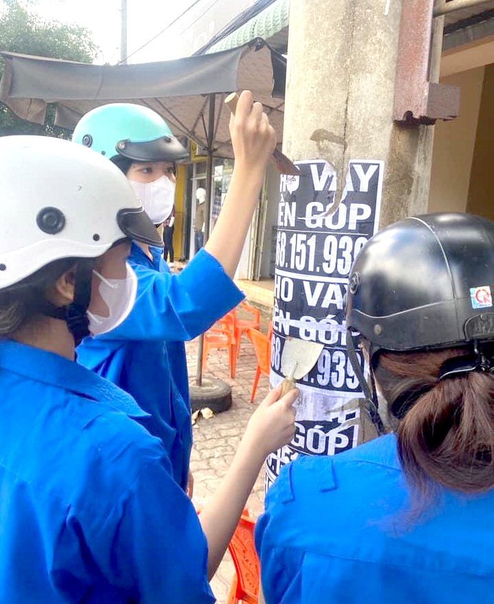 Đoàn viên thanh niên huyện Châu Đức gỡ các quảng cáo cho vay tiền dán trên cột điện.