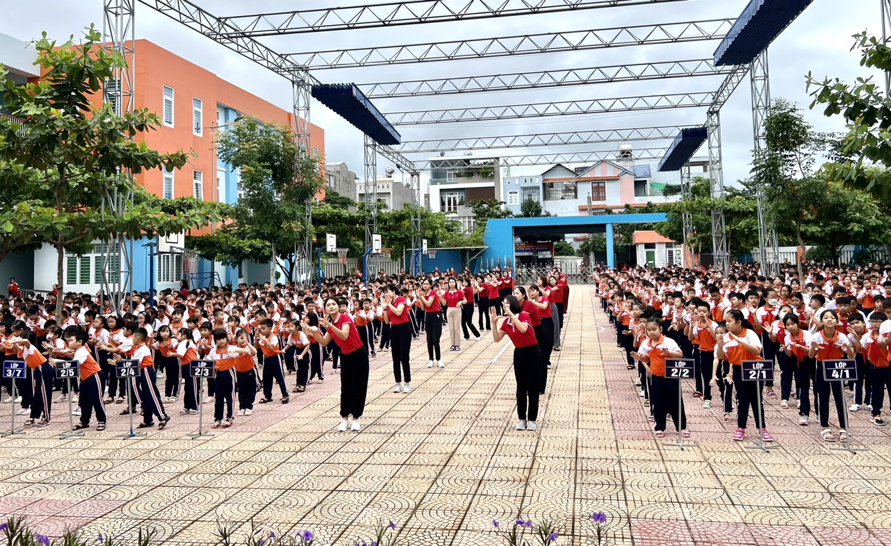 Các cô giáo và toàn thể học sinh đồng diễn múa hát sân trường.