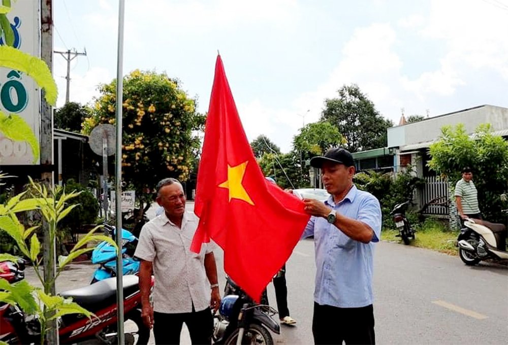 Đảng viên và Nhân dân ấp Mỹ An, xã Long Mỹ hưởng ứng lắp trụ cờ trong mô hình khu dân cư  “sáng - xanh - sạch” của xã.