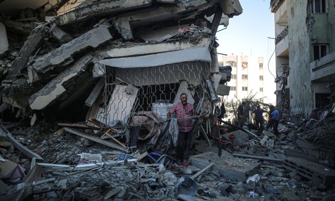 Một cư dân ở thành phố Gaza đứng giữa đống đổ nát của những tòa nhà đã bị phá hủy ở khu phố al-Zahra.
