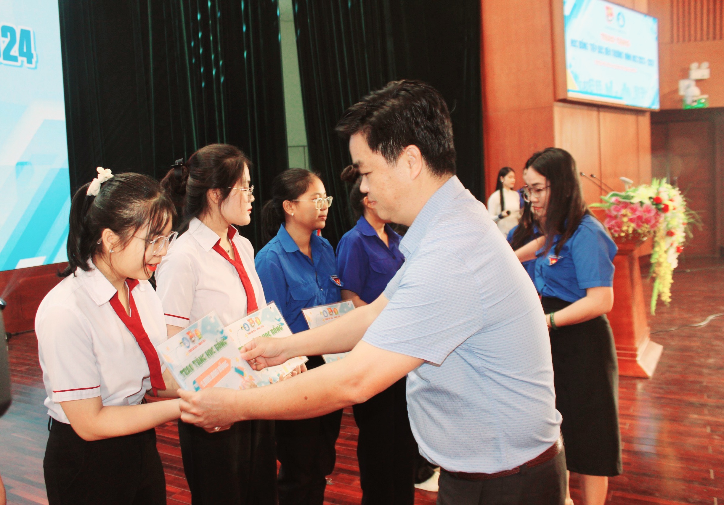 Ông Lê Văn Minh, Phó Trưởng ban Tuyên giáo Tỉnh uỷ trao học bổng cho các em HS, SV có hoàn cảnh khó khăn.