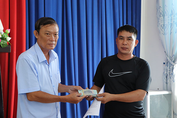 Phó Chủ tịch Hội Nông dân huyện Long Điền  Huỳnh Văn Sơ (bên trái) trao vốn vay 50 triệu đồng cho hội viên nông dân Huỳnh Ngọc Trung (ấp An Phước).
