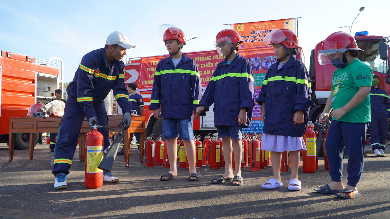 Các em học sinh trải nghiệm chữa cháy dưới sự hướng dẫn của cảnh sát PCCC và CNCH.