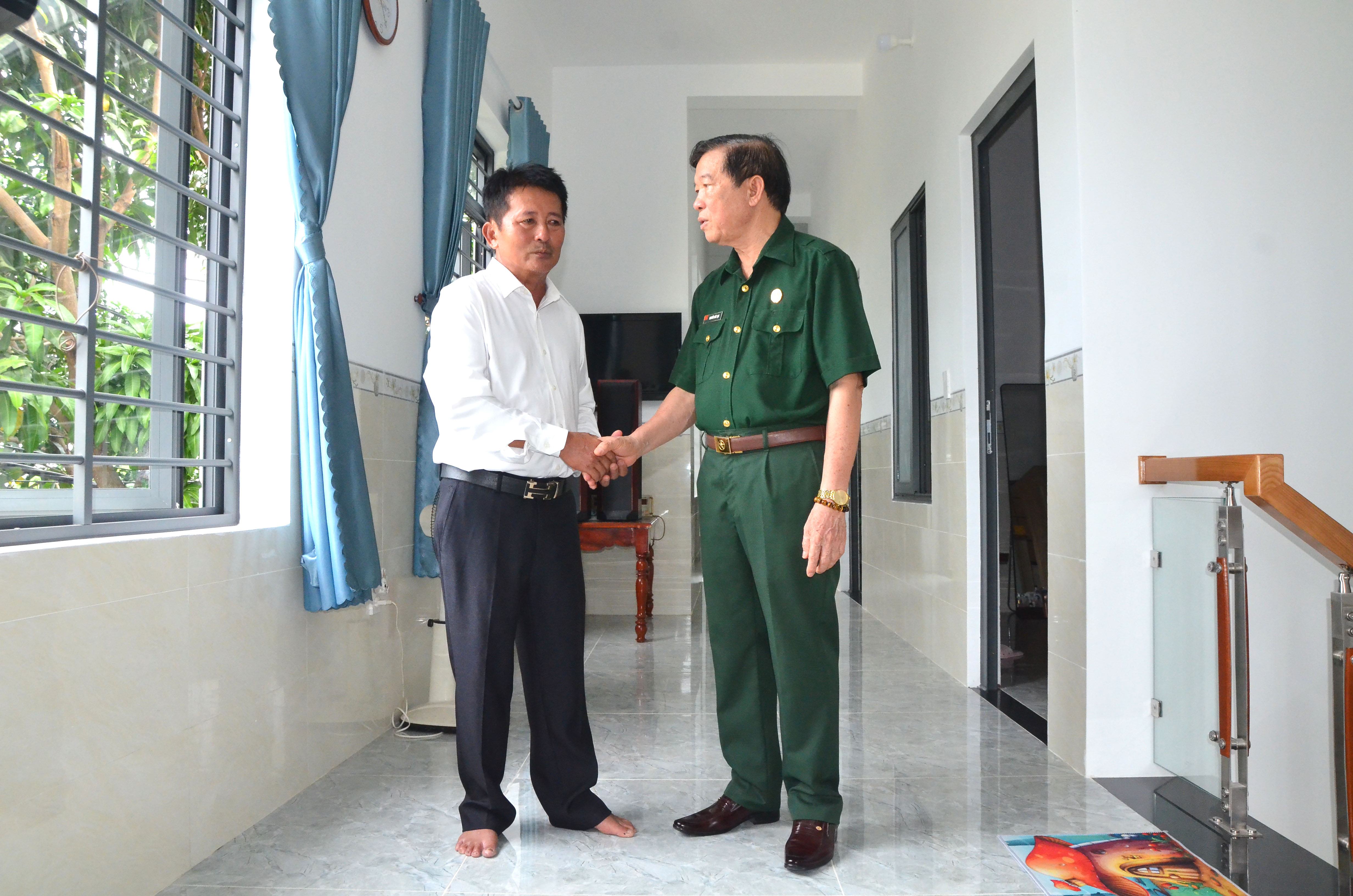 Cựu chiến binh Nguyễn Đức Lạc chia sẻ niềm vui có nhà mới với ông Võ Đình Quang.