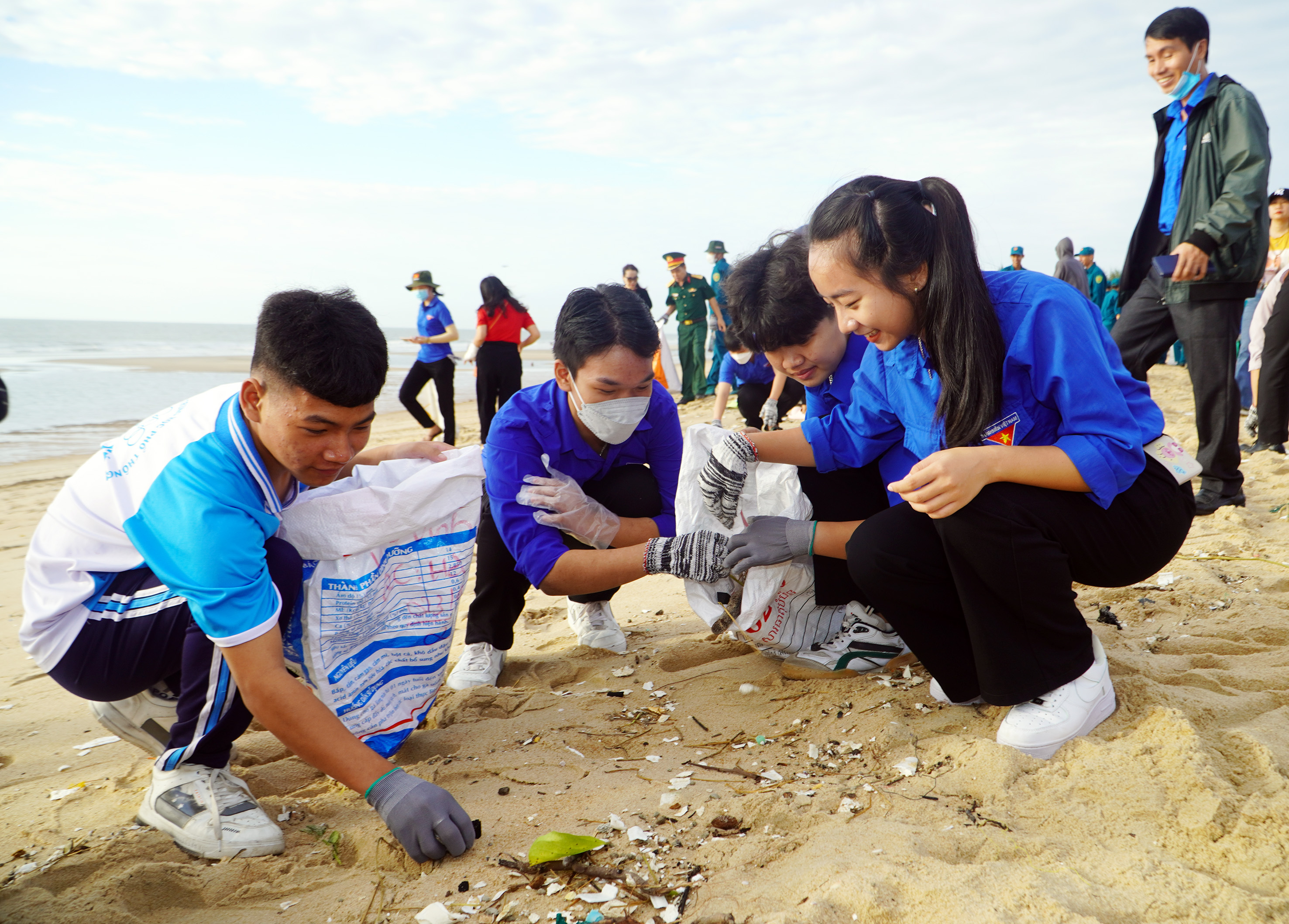 Các em HS, SV, đoàn viên thanh niên nhặt rác làm sạch bãi biển.