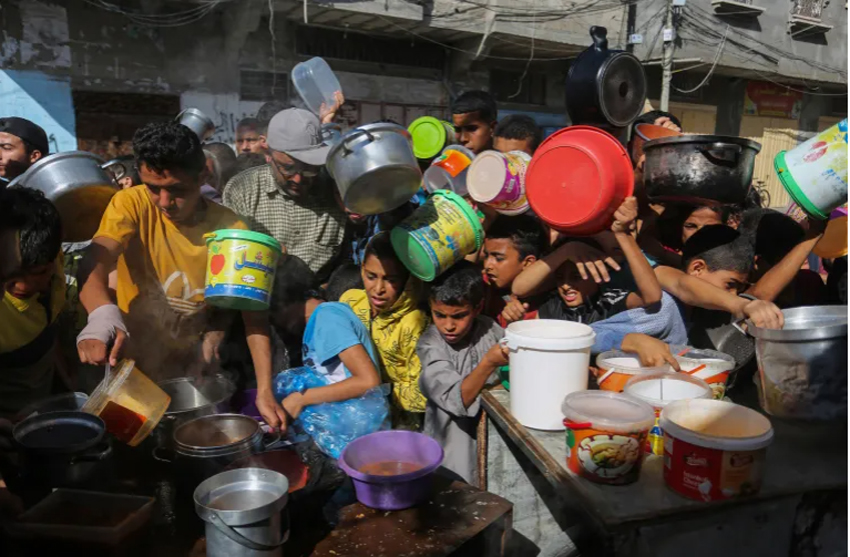Người Palestin nhận thức ăn cứu trợ trong khi nguồn cung rất ít ỏi.