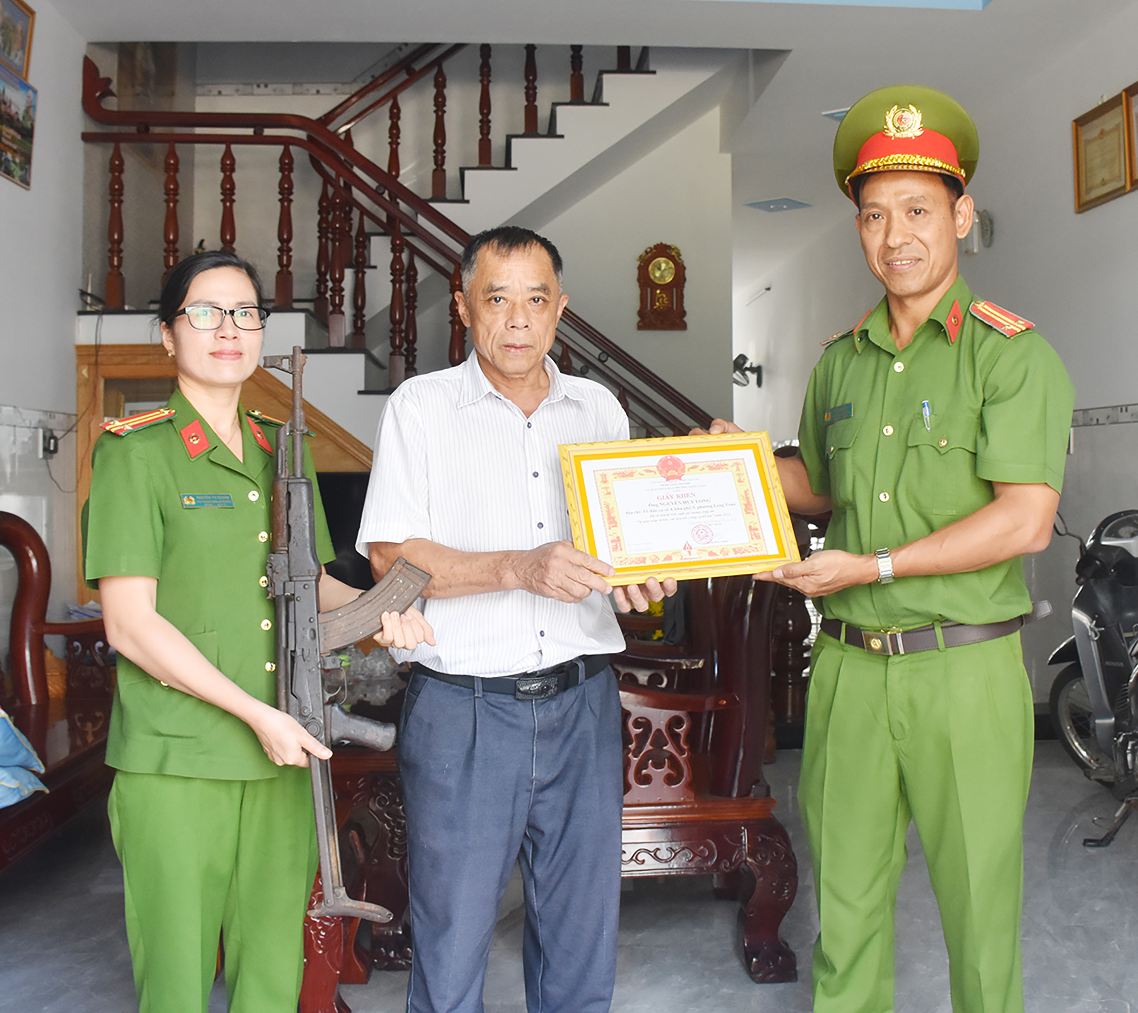 Lãnh đạo Công an phường Long Toàn (TP.Bà Rịa) tặng giấy khen cho người dân tự nguyện giao nộp vũ khí.