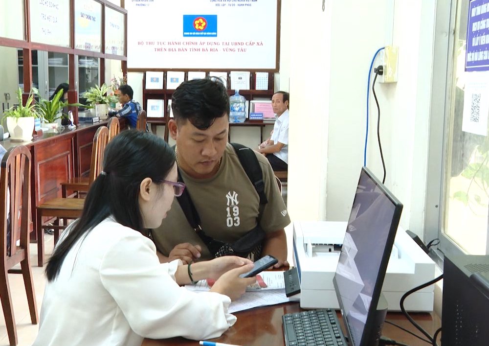 Công chức Bộ phận một cửa UBND phường 12 hướng dẫn người dân thực hiện thủ tục trực tuyến.
