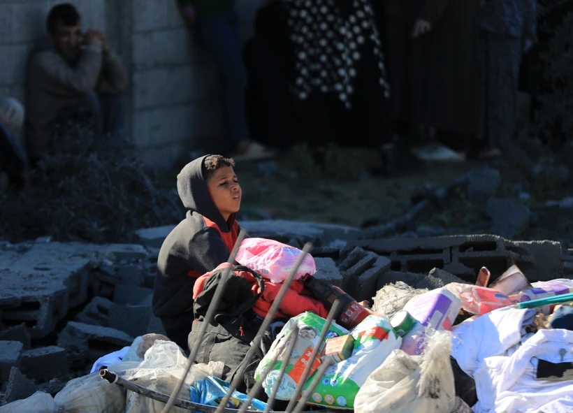 Một em nhỏ Palestine ngồi giữa đống đổ nát sau cuộc oanh kích của Israel xuống thành phố Rafah, Dải Gaza.