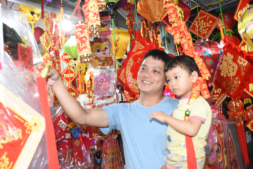 Anh Phan Văn Hoàng và bé Thuỳ Tiên (2 tuổi) ngắm nhìn đồ trang trí Tết tại cửa hàng Hải Ngân (286 Thống Nhất mới, TP. Vũng Tàu).