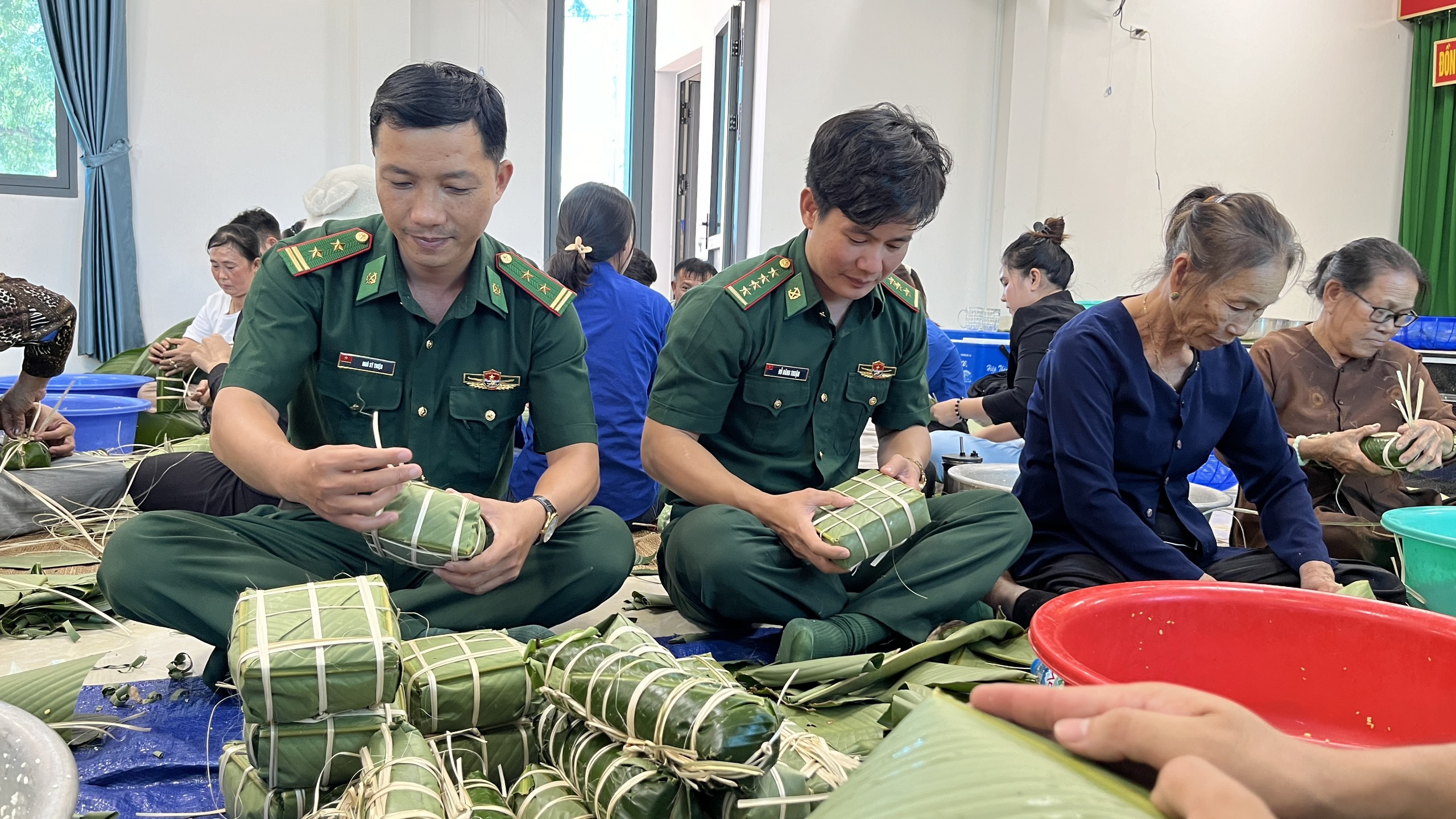 Cán bộ Đồn Biên phòng Bình Châu và người dân tham gia gói bánh chưng, bánh tét tặng người nghèo.