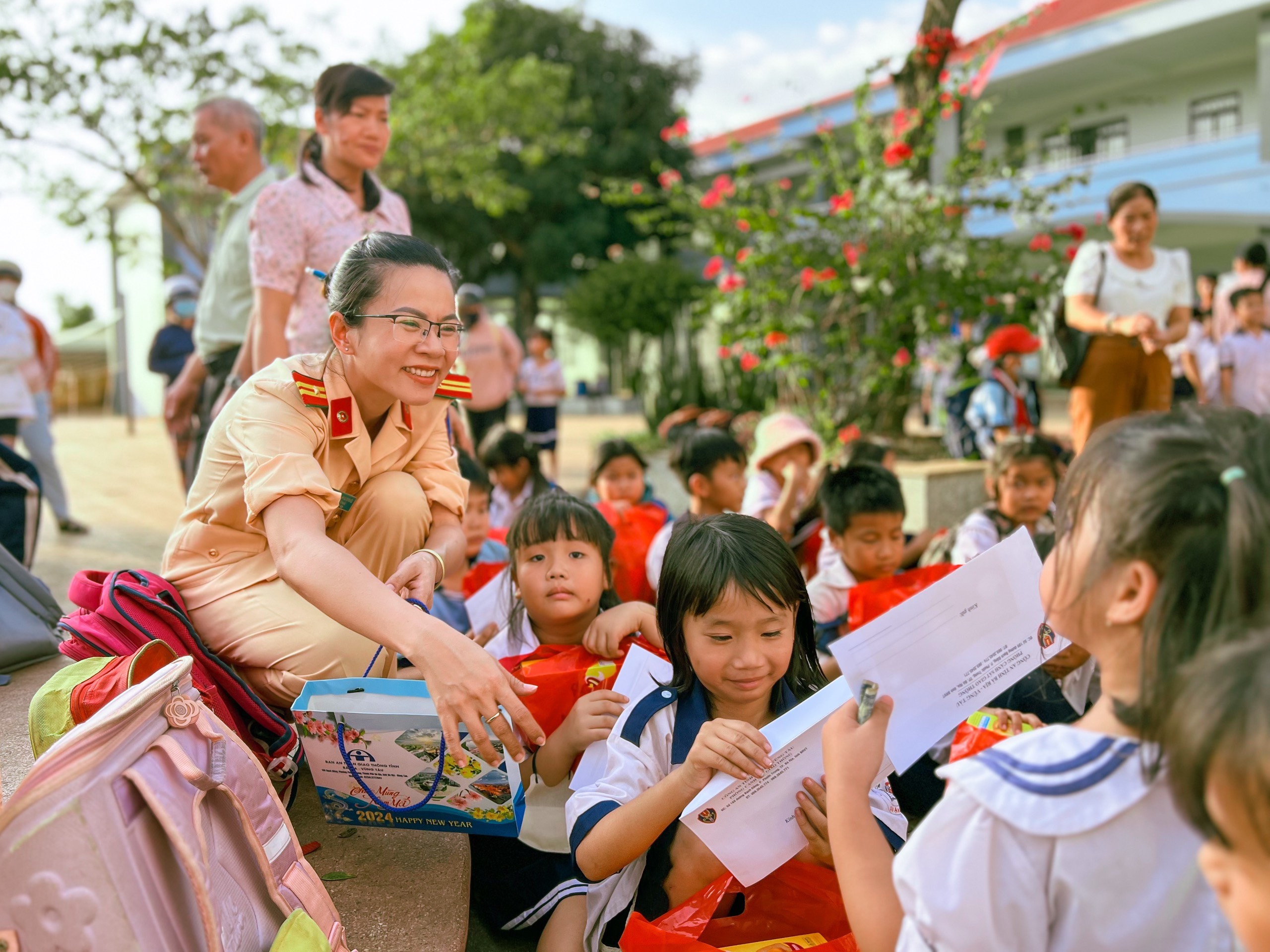 Cán bộ CSGT tặng các suất quà đến HS có hoàn cảnh khó khăn tại trường tiểu học Thống Nhất (xã Tân Lâm, H.Xuyên Mộc)