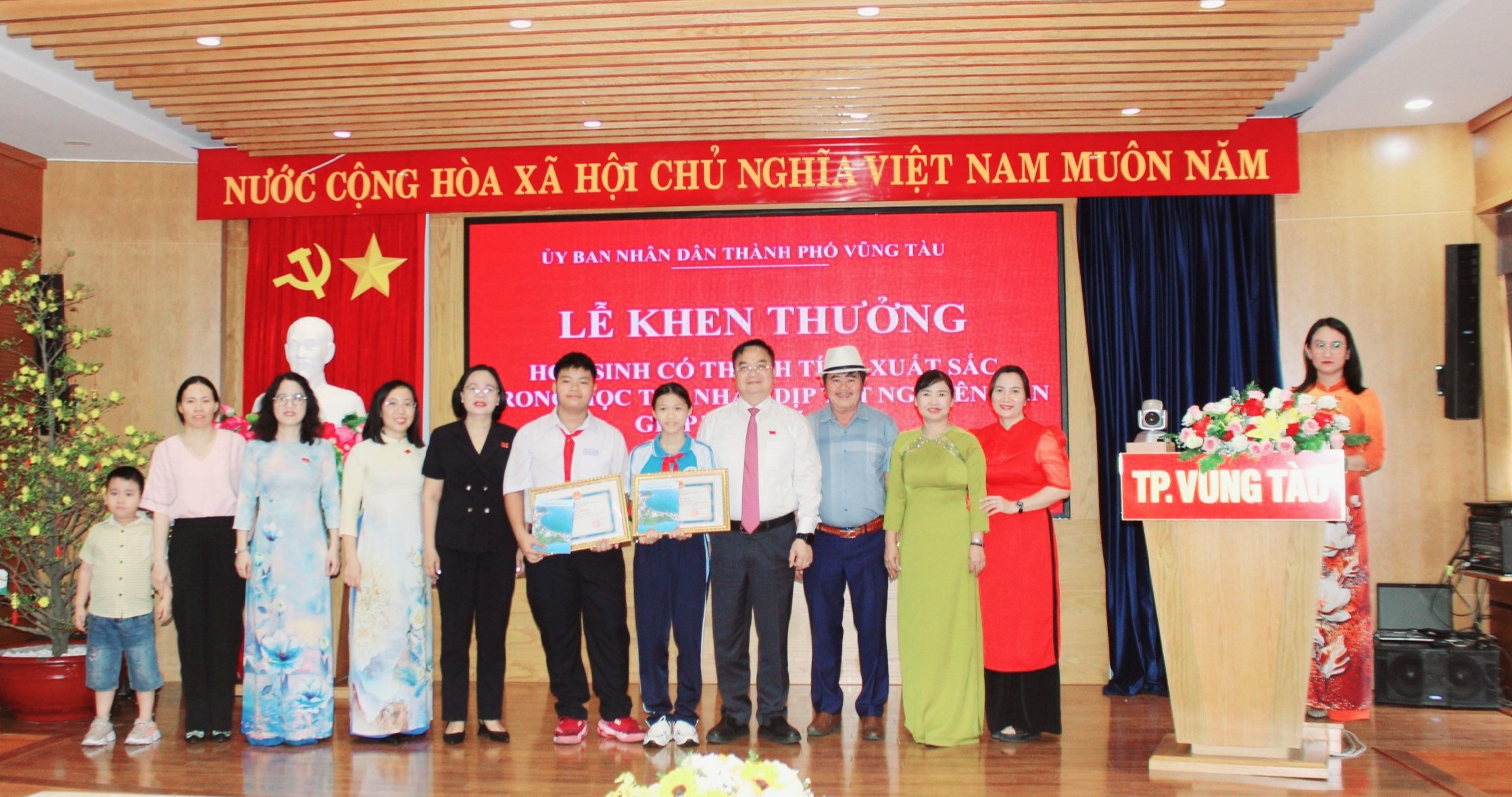 Lãnh đạo thành phố chụp hình lưu niệm với các em HS được khen thưởng.