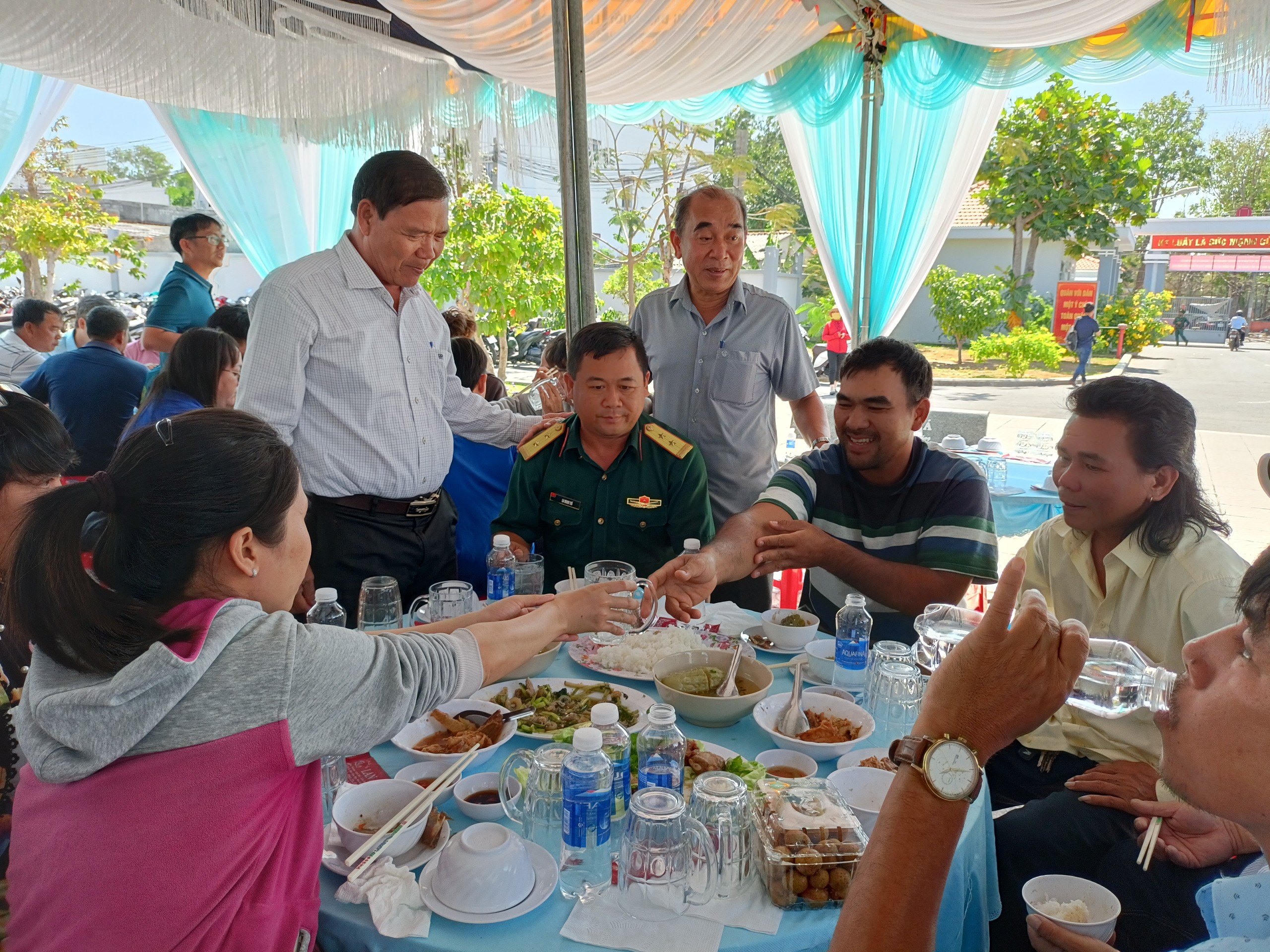 Ông Lâm Văn Hồng, Chủ tịch UBND huyện Long Điền (người đứng bên phải) trò chuyện với ngư dân trong buổi họp mặt đầu xuân, dùng cơm trưa ngày 17/2.