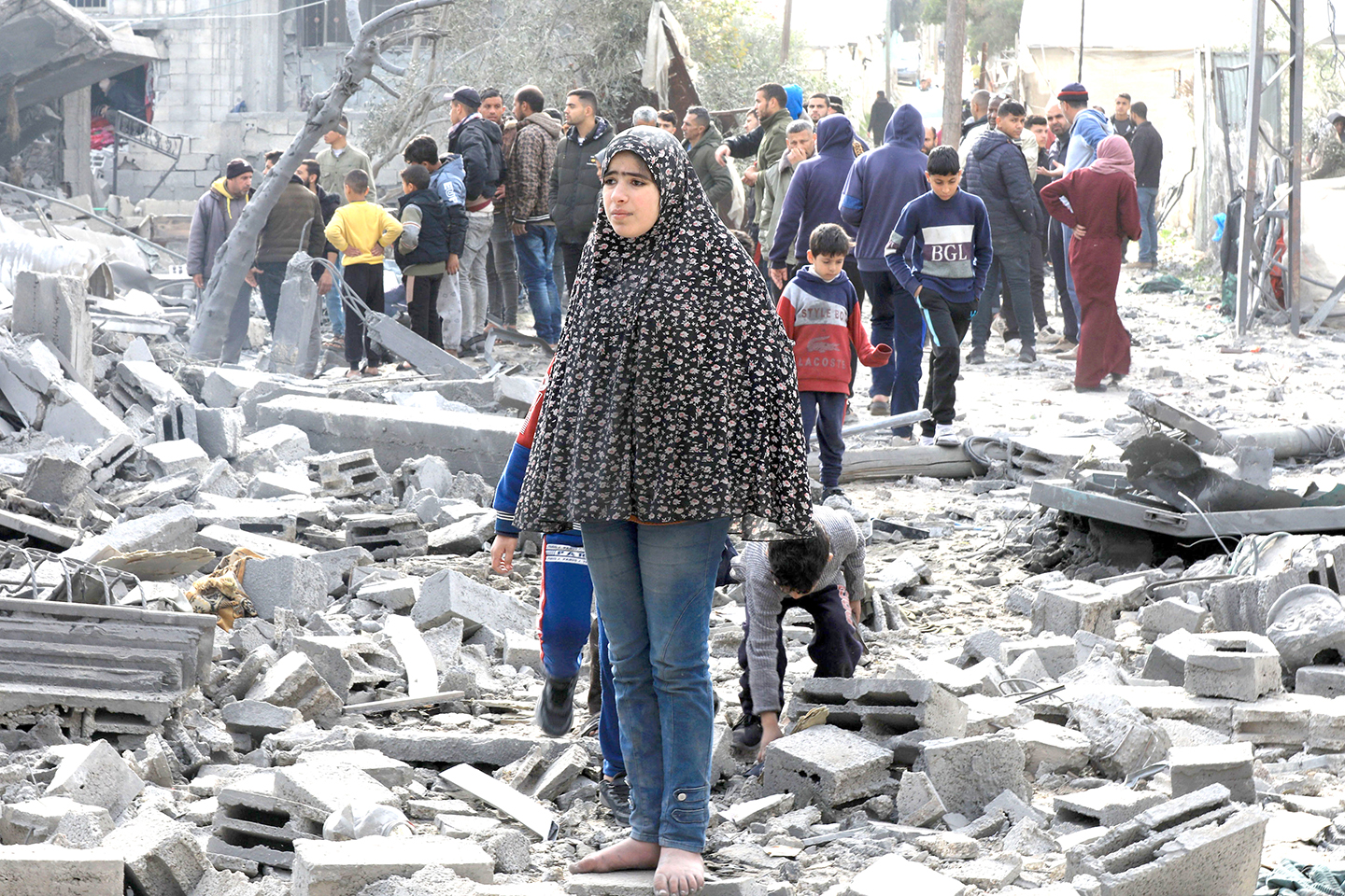 Người dân Palestine bên đống đổ nát của những tòa nhà bị phá hủy sau các cuộc không kích của Israel tại thành phố Rafah, Dải Gaza.