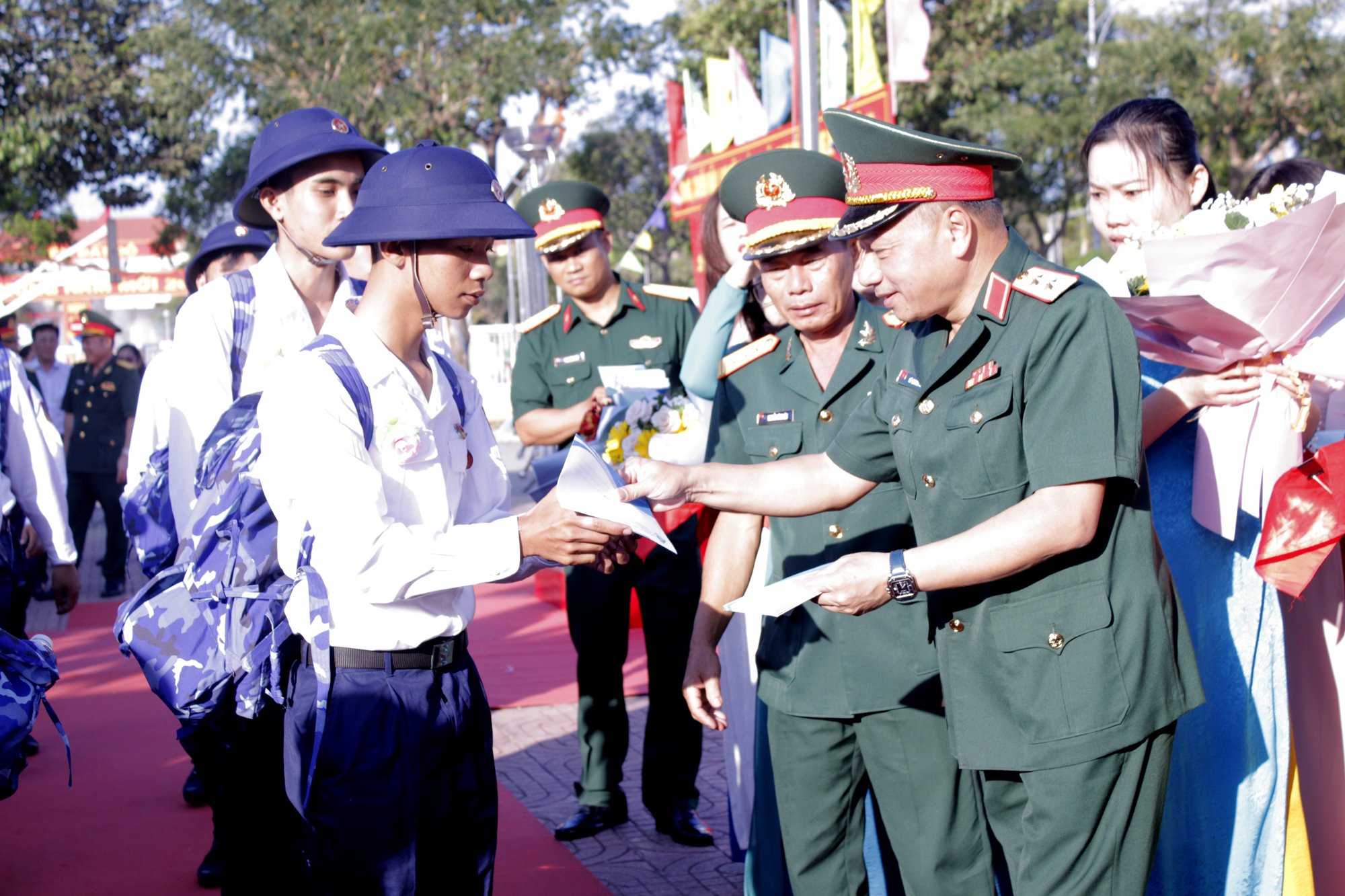 Trung tướng Lê Quang Minh, Phó Chủ nhiệm Tổng cục Chính trị Quân đội nhân dân Việt Nam tặng hoa và quà cho các tân binh huyện Đất Đỏ tại lễ giao quân sáng 27/2. Ảnh: VÂN ANH