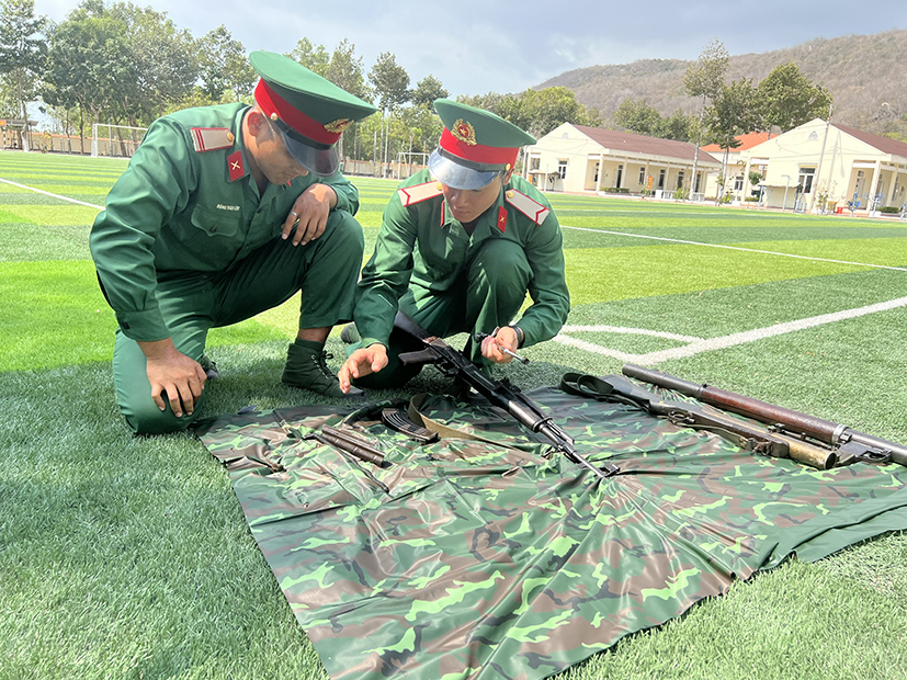 Mặc trời nắng nóng, chiến sĩ mới vẫn miệt mài học cách tháo lắp súng.