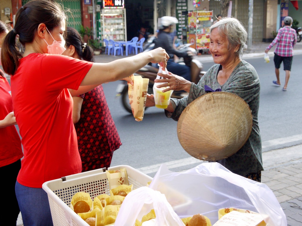 Bà Nguyễn Thị Mến nhận phần bánh mì và nước giải khát miễn phí.