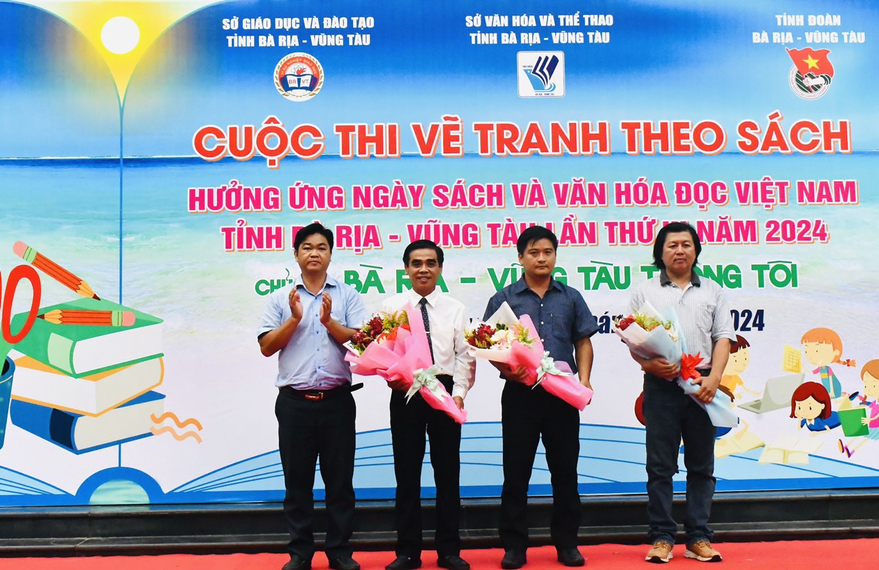 Ông Lê Văn Minh, Phó Ban Tuyên giáo Tỉnh ủy tặng hoa đến Ban Giám khảo cuộc thi.