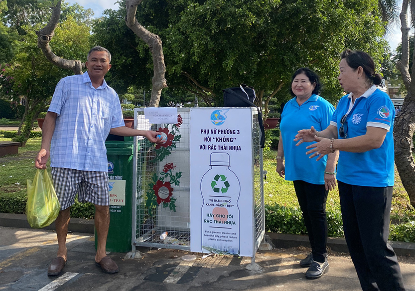 Cán bộ, hội viên Hội LHPN phường 3 vận động người dân gom rác thải tái chế bỏ vào thùng rác ở Công viên Trần Hưng Đạo.