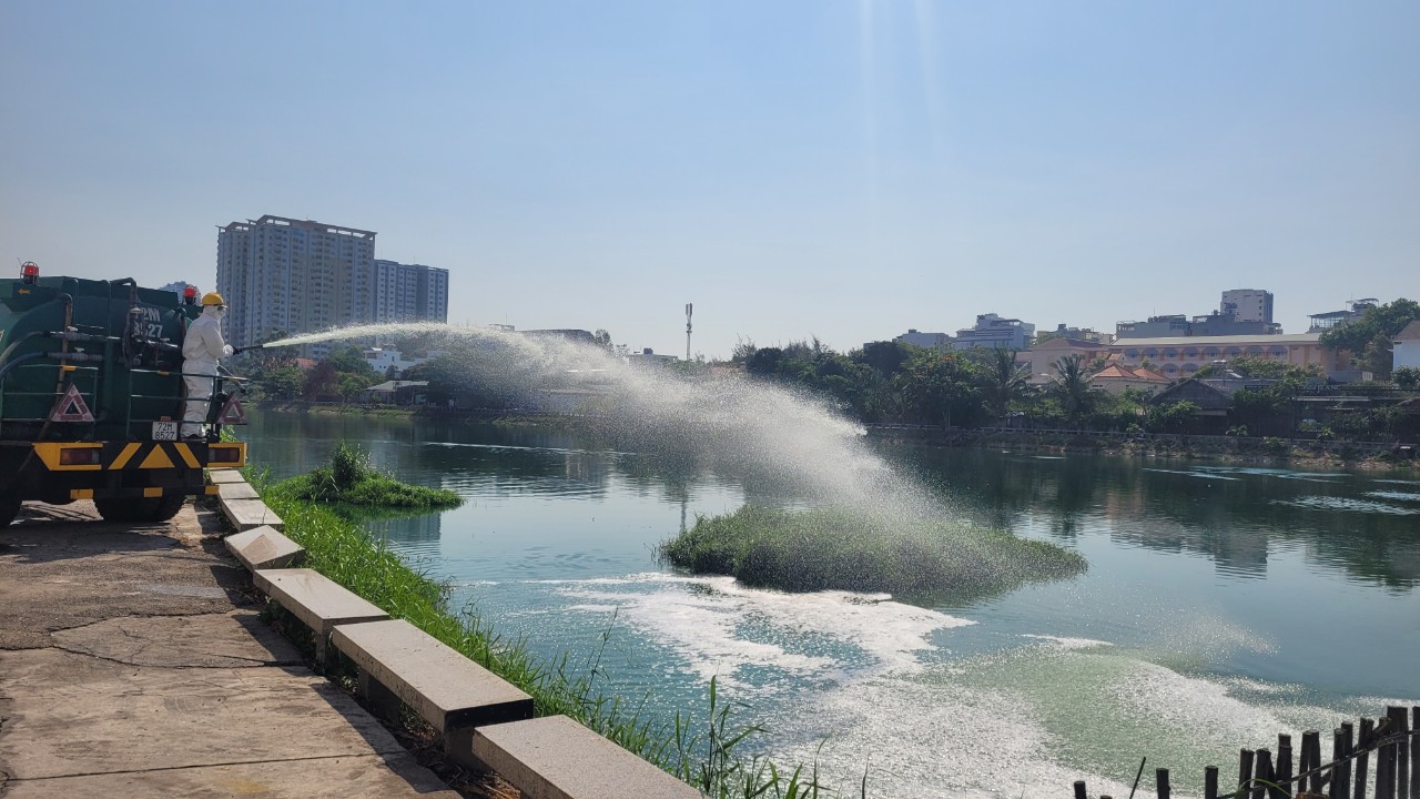 Công nhân UPC phun chế phẩm sinh học xuống hồ Bàu Sen để cắt tảo đáy, giảm mùi hôi