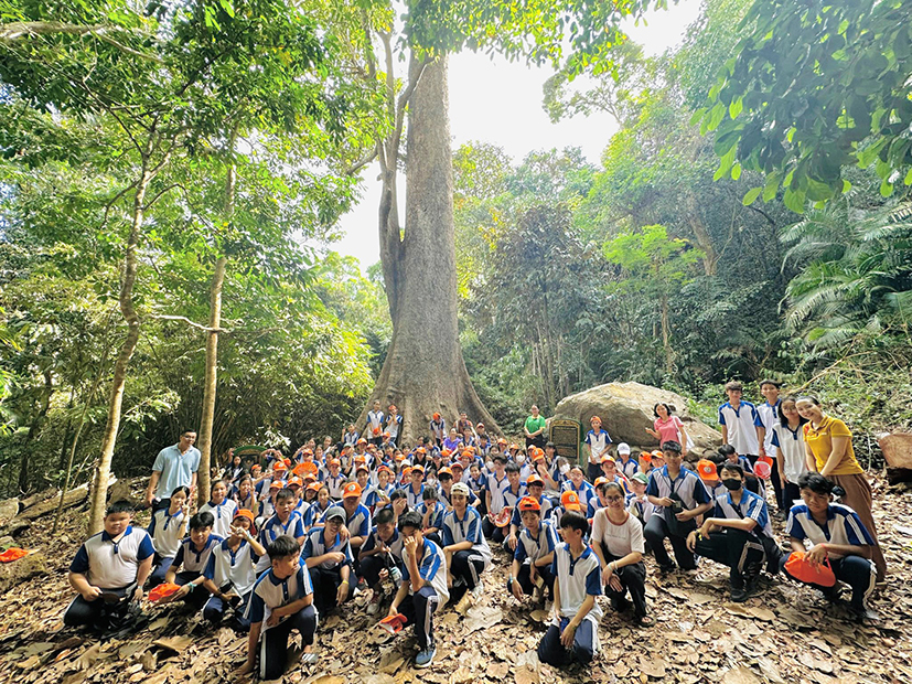 Học sinh tham gia “Hành trình về với cây di sản”, chụp hình lưu niệm dưới gốc cây nhội 400 năm tuổi ở Vườn Quốc gia Côn Đảo ngày 4/5.