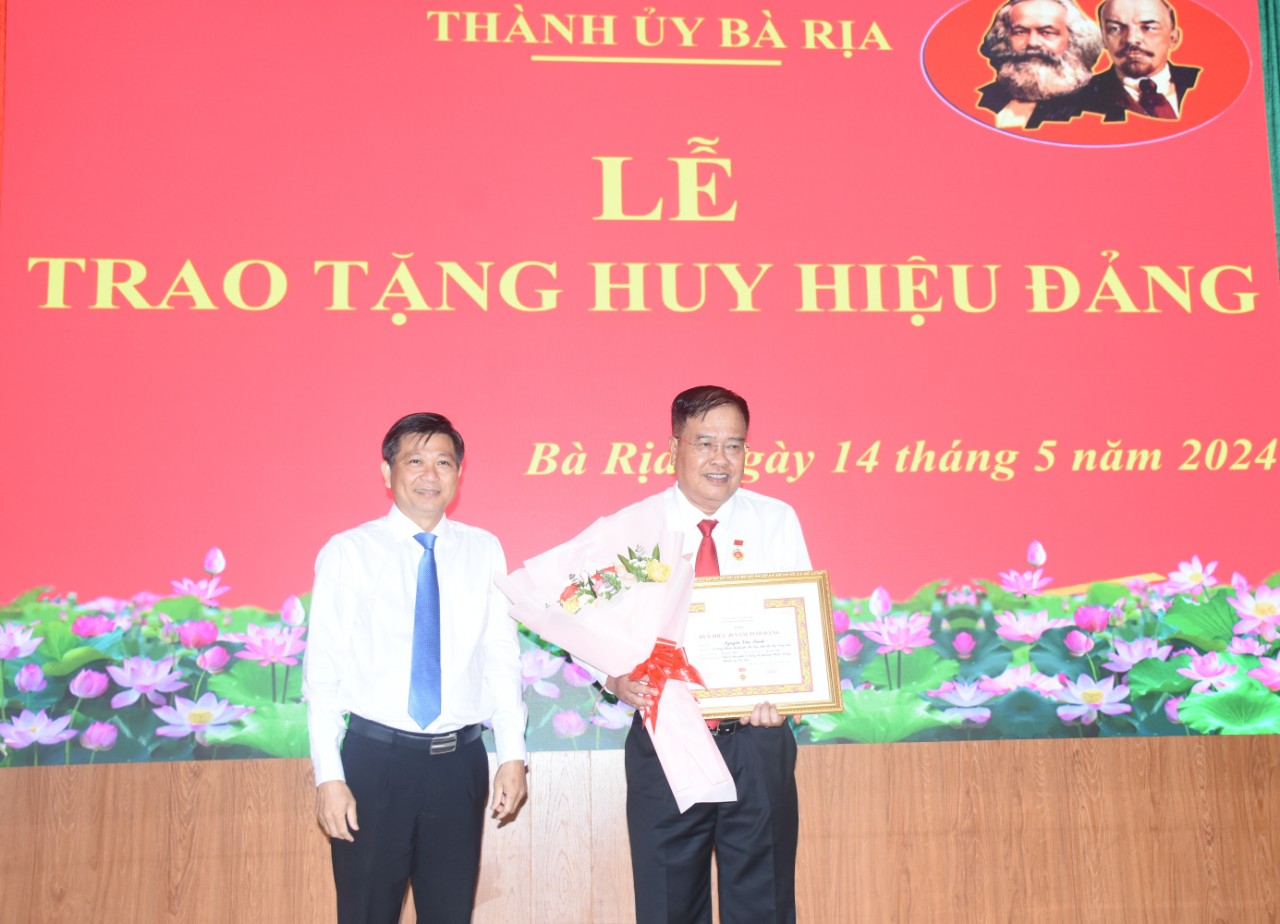 Bí thư Thành uỷ Bà Rịa Trần Văn Tuấn trao Huy hiệu 40 năm tuổi Đảng cho đảng viên Nguyễn Văn Trình.