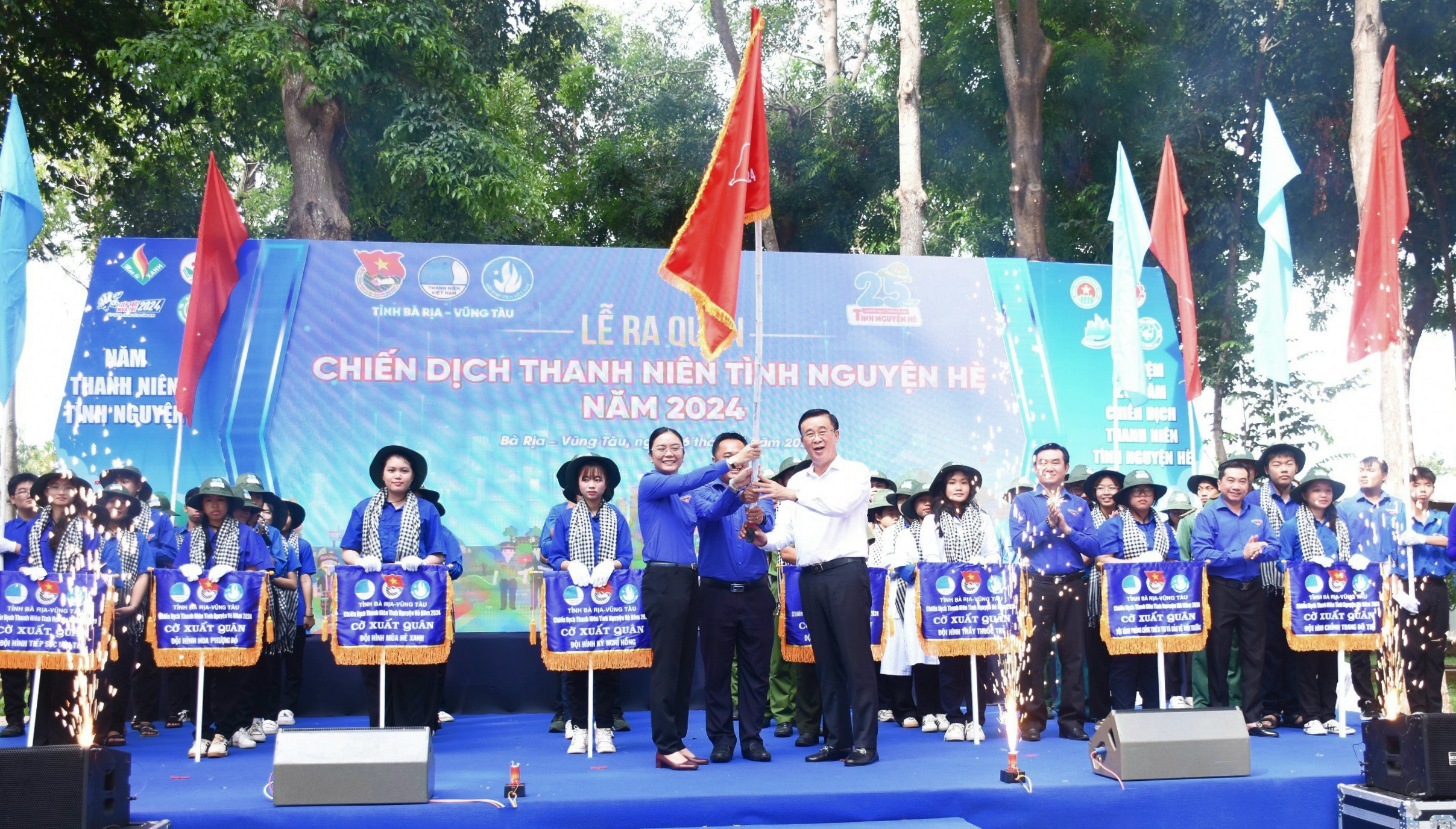 Ông Huỳnh Văn Danh, Trưởng Ban Dân vận Tỉnh ủy trao cờ xuất quân cho Chỉ huy chiến dịch Thanh niên tình nguyện hè tại lễ ra quân.