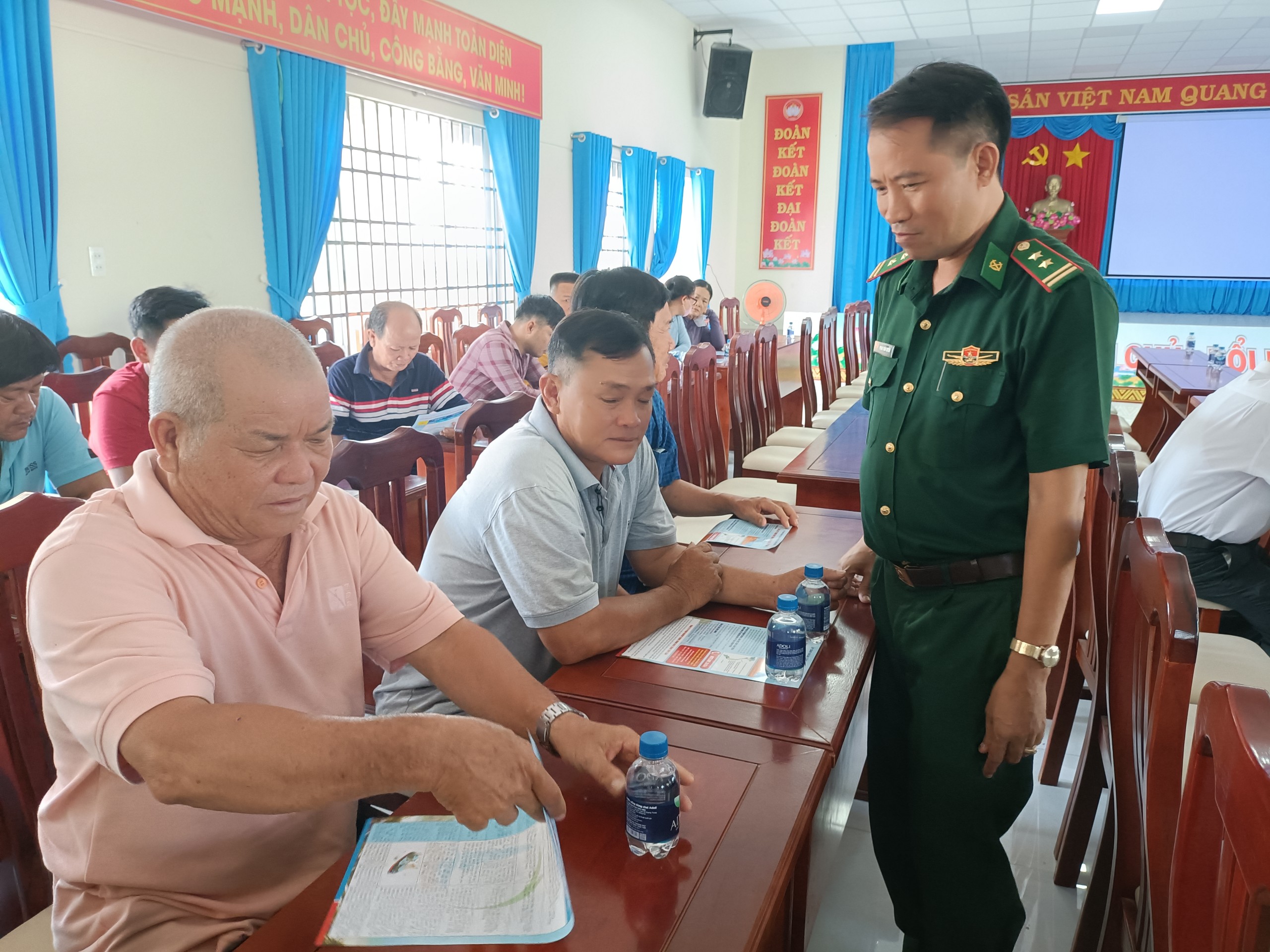 Đại diện Đồn biên phòng Phước Tỉnh vận động chủ tàu cá liên lạc thuyền trưởng đưa các phương tiện tháo máy GSHT gửi trên 1 tàu cá vào bờ trong buổi họp mặt ngư dân ngày 23/4.