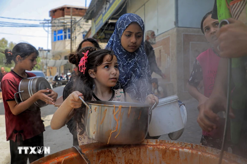 Trẻ em Palestine nhận thức ăn cứu trợ tại thành phố Rafah, Dải Gaza.