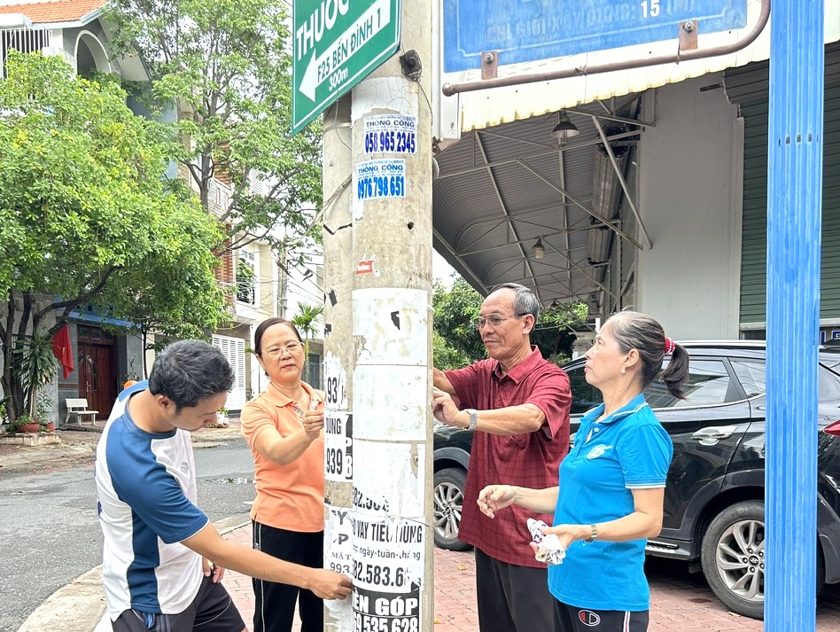 Người dân phường Thắng Nhì, TP.Vũng Tàu tham gia xóa quảng cáo rao vặt trái phép trên cột điện ngày 9/6.