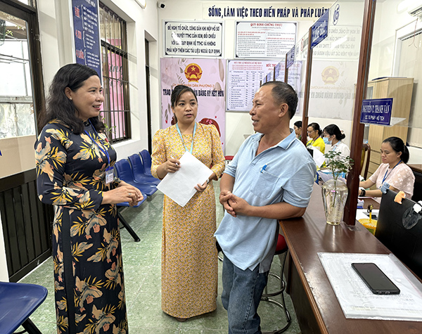 Bà Vũ Phương Hảo (bìa trái), Bí thư Đảng ủy, Chủ tịch UBND phường 2 (TP.Vũng Tàu) gặp gỡ người dân  khi họ đến giải quyết thủ tục hành chính tại Bộ phận một cửa của phường.