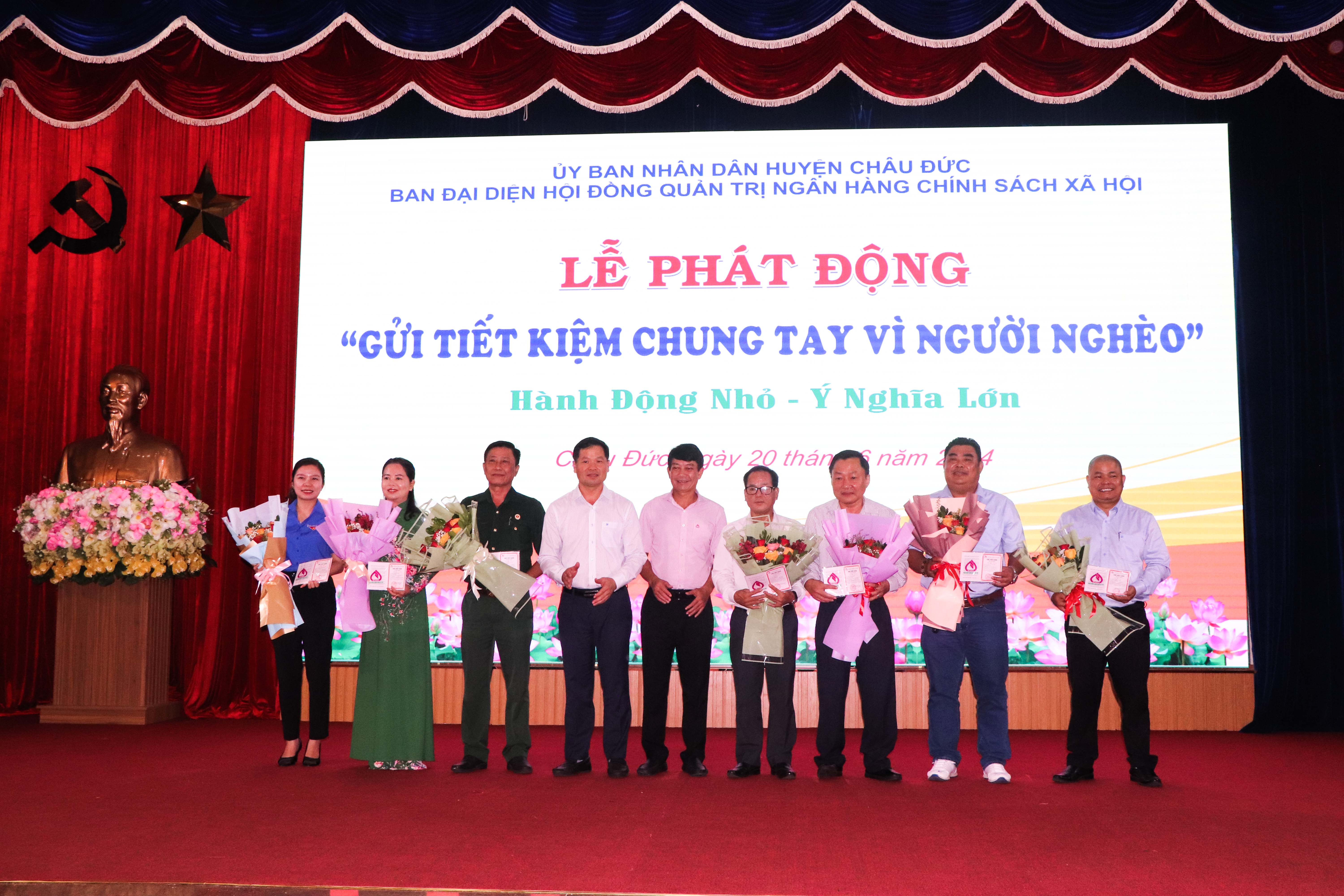 Ông Lê Thanh Liêm (thứ 4 từ trái vào), Phó Bí thư Thường trực Huyện ủy Châu Đức và lãnh đạo Chi nhánh Ngân hàng CSXH tỉnh trao sổ gửi tiết kiệm và tặng hoa cho các tổ chức, cá nhân tại lễ phát động.