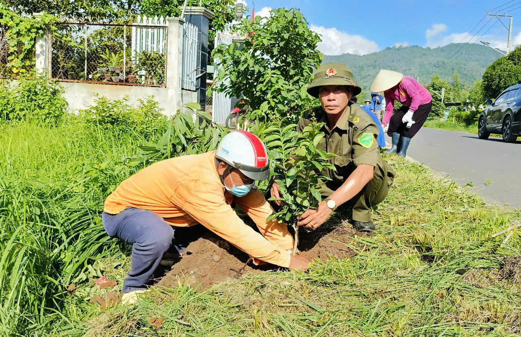 Cán bộ, nhân dân trồng cây bằng lăng dọc tuyến đường nhằm tạo cảnh quan môi trường.