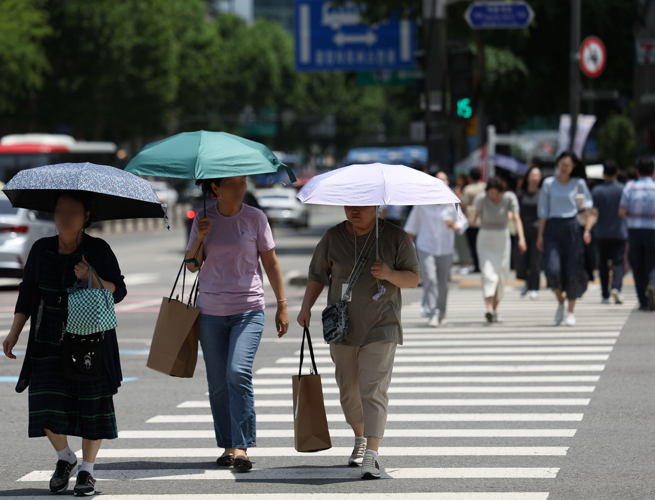 Người dân di chuyển trên đường phố dưới trời nắng nóng tại Seoul, Hàn Quốc.