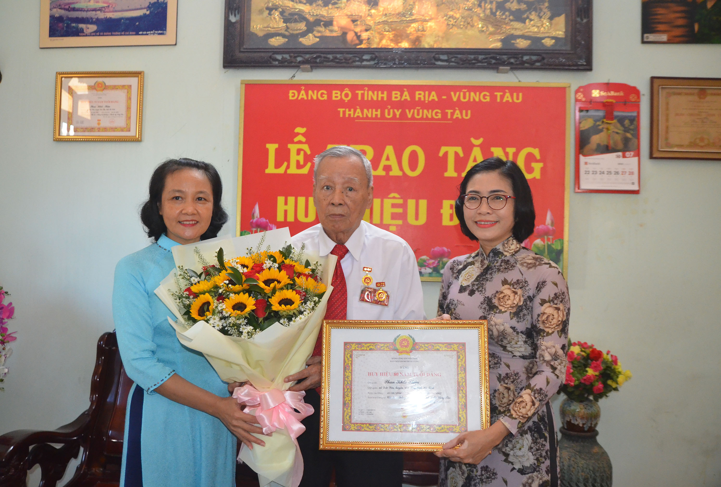 à Lê Thị Thanh Bình, Phó Bí thư Thường trực Thành ủy, Chủ tịch HĐND TP.Vũng Tàu; bà Nguyễn Thị Ngọc Thủy, Trưởng Ban Tổ chức Thành ủy Vũng Tàu trao Huy hiệu đảng và tặng hoa chúc mừng đảng viên Phan Khắc Thiệu.