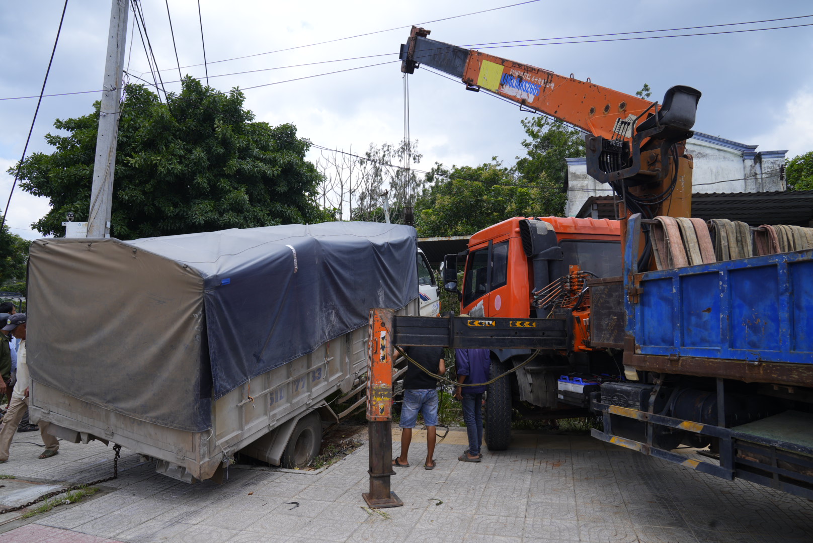 Xe cẩu được điều tới hiện trường đưa nạn nhân kẹt cứng dưới gầm xe tải lên. 