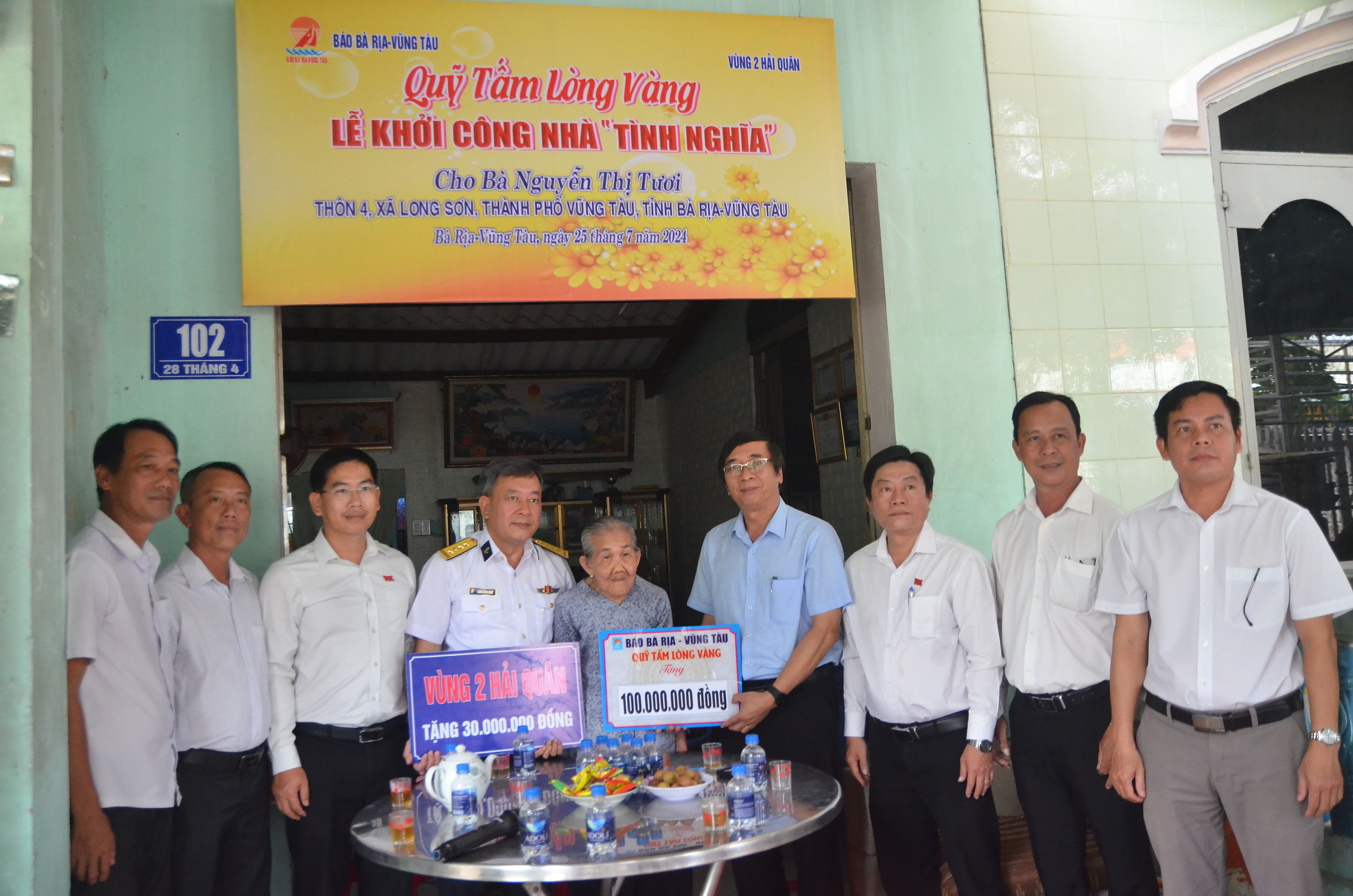 Ông Trương Đức Nghĩa, Tổng Biên tập Báo Bà Rịa - Vũng Tàu và Đại tá Hoàng Minh Dũng, Phó Chủ nhiệm Chính trị Vùng 2 Hải quân trao bảng tượng trưng trích kinh phí hỗ trợ xây nhà tình nghĩa cho bà Nguyễn Thị Tươi.