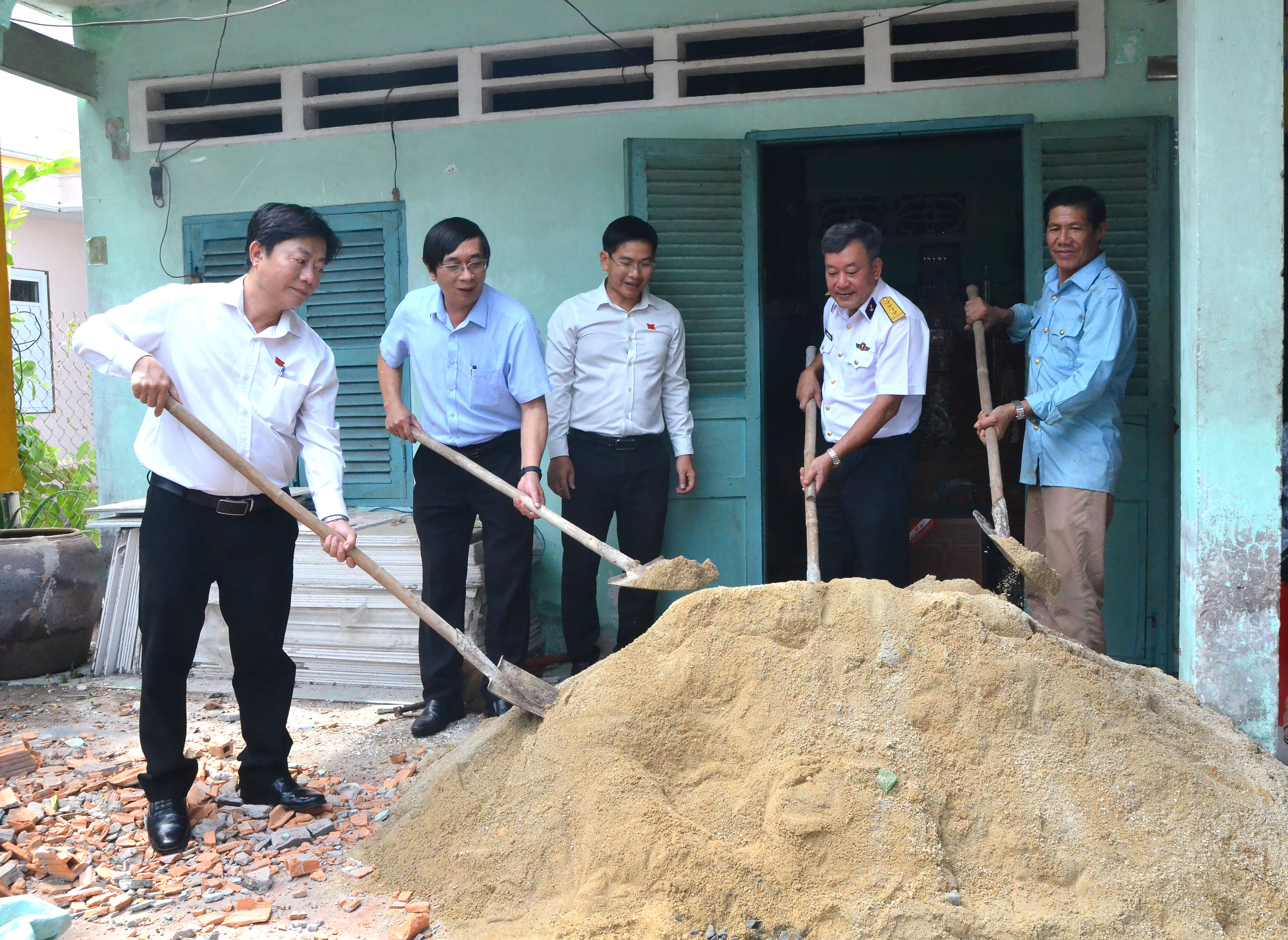 Các đại biểu thực hiện nghi thức động thổ xây nhà tình nghĩa tặng bà Nguyễn Thị Tươi.