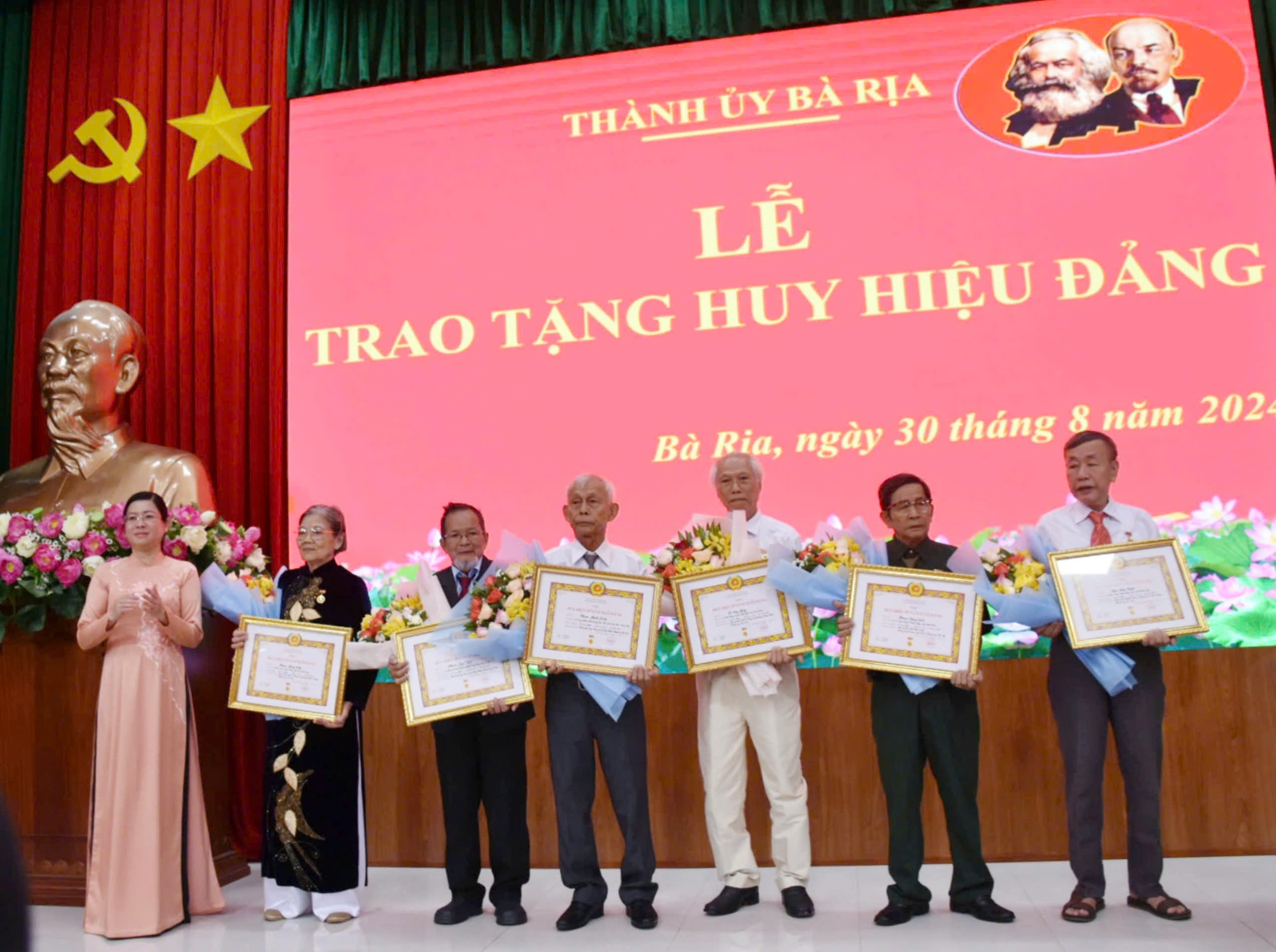 Phó Bí thư  Thường trực Thành ủy Lê Thị Thủy trao Huy hiệu 55 năm tuổi Đảng cho các đảng viên.