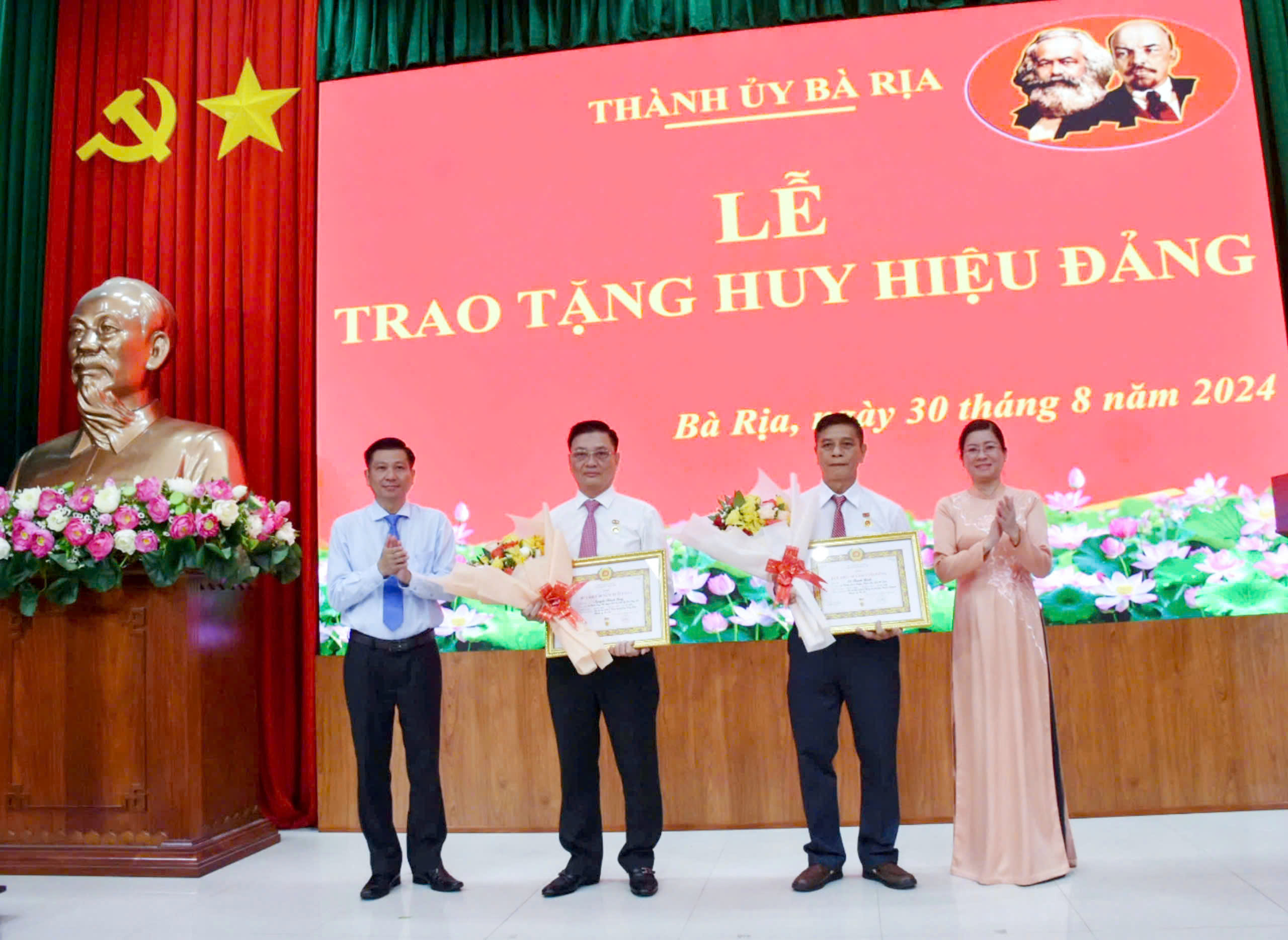  Bí thư Thành ủy Bà Rịa Trần Văn Tuấn và Phó Bí thư  Thường trực Thành ủy Lê Thị Thủy trao tặng Huy hiệu 40 năm tuổi Đảng cho Đảng viên Nguyễn Thành Long, nguyên Phó Chủ tịch UBND tỉnh (Đảng bộ phường Long Toàn) và đảng viên Từ Thanh Bình (Đảng bộ phường Phước Nguyên).