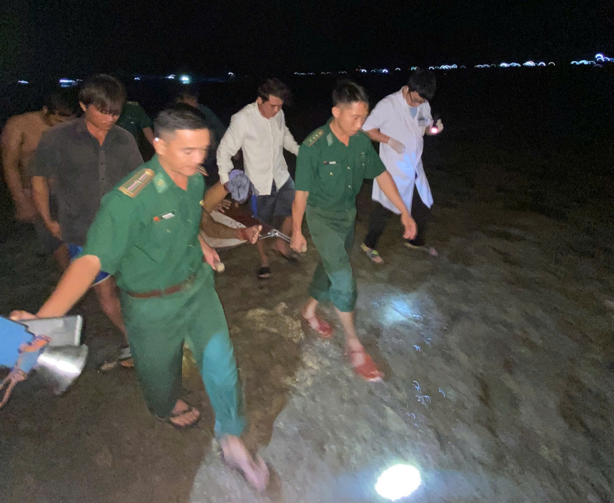 Lực lượng chức năng tiếp nhận, đưa thuyền viên bị nạn vào bờ. Ảnh: Q.A