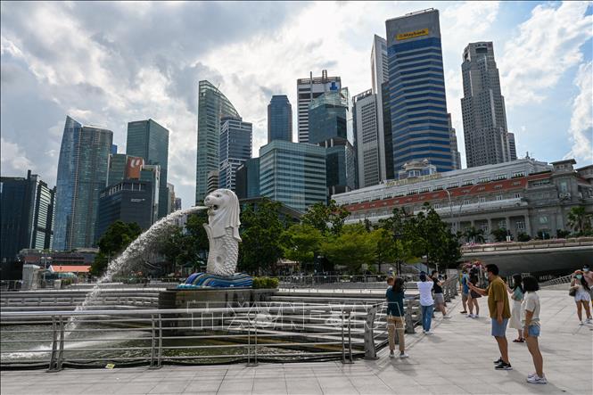 Khách du lịch chụp ảnh bên tượng nhân sư Merlion tại Singapore.