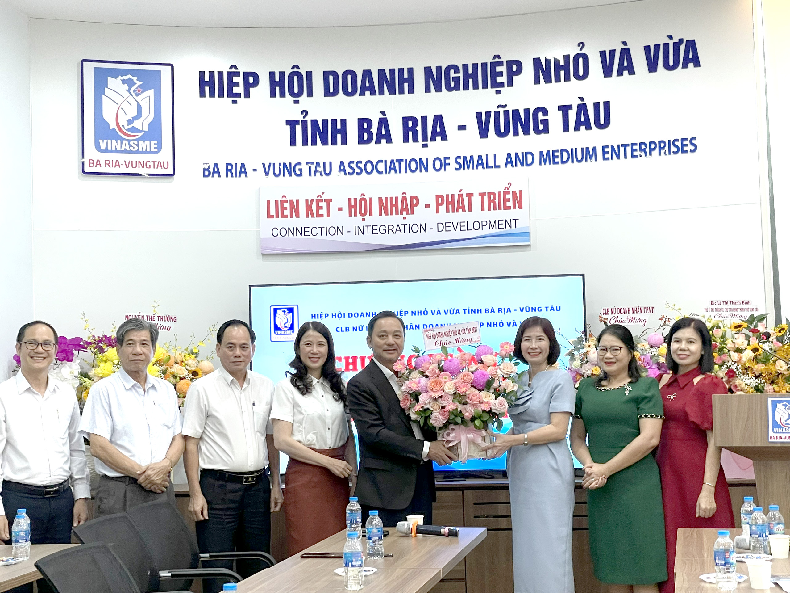 Ông Phạm Văn Triêm, Chủ tịch Hiệp hội DNNVV tỉnh tặng hoa chúc mừng CLB nữ doanh nhân DNNVV tỉnh. Ảnh: PHAN HÀ