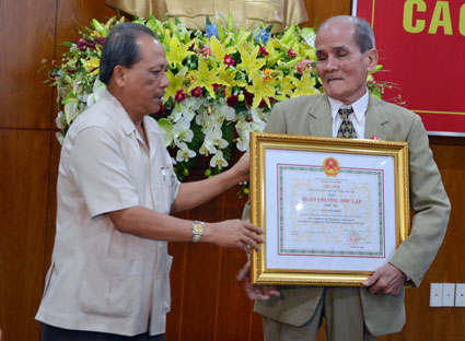 Thừa ủy quyền của Chủ tịch nước, ông Nguyễn Tuấn Minh (trái), Ủy viên Trung ương Đảng, Bí thư Tỉnh ủy trao Huân chương Độc lập hạng Nhất cho ông Lê Quang Thành (tháng 1/2024). Ảnh: ĐỨC NGUYÊN