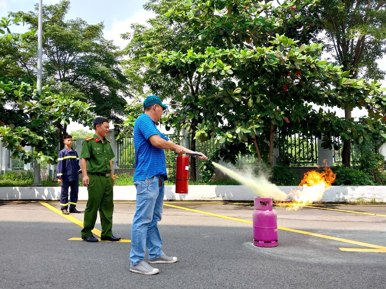 Các học viên thực hành sử dụng bình chữa cháy cầm tay dập lửa. 