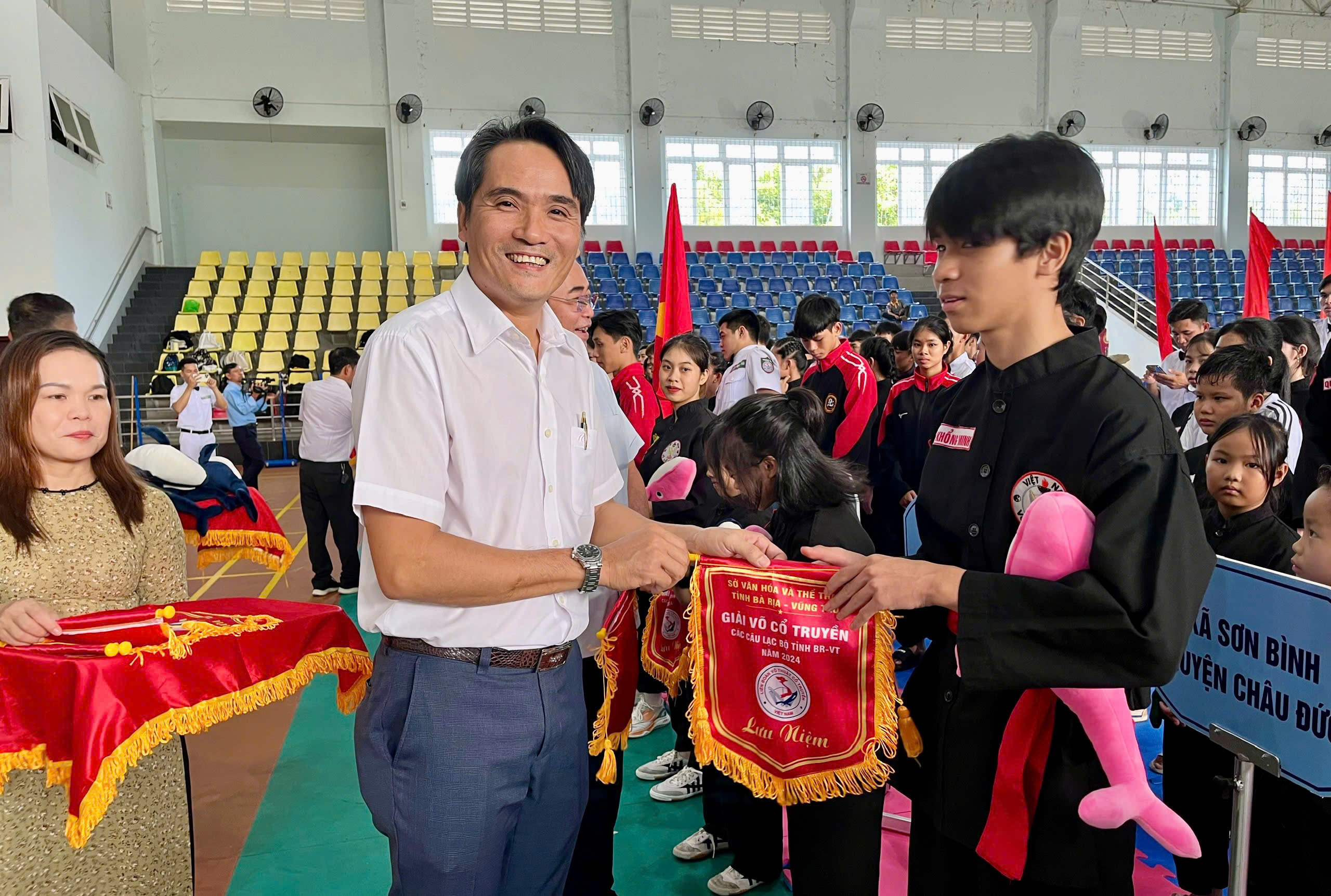 Ông Nguyễn Thanh Phong, Phó giám đốc Trung tâm Huấn luyện và thi đấu tỉnh trao cờ lưu niệm cho các đoàn tham dự giải.