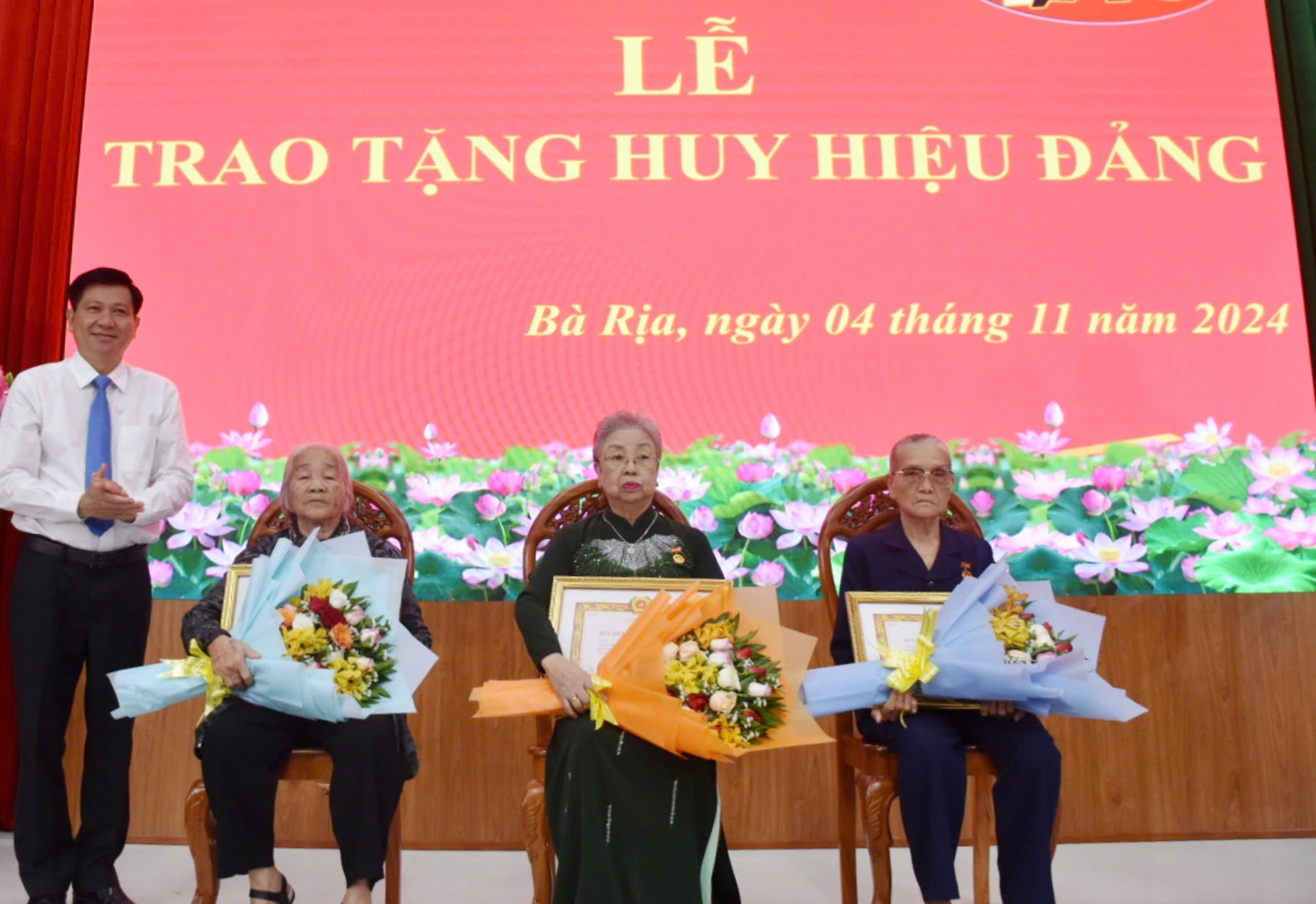 Bí thư Thành ủy Bà Rịa Trần Văn Tuấn trao Huy hiệu 60 năm tuổi Đảng và tặng hoa chúc mừng các đảng viên.